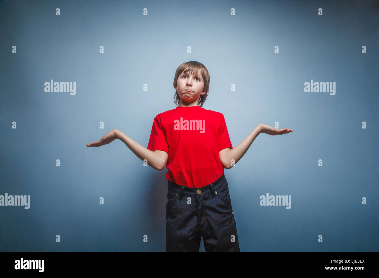 Garçon, adolescent, douze ans en rouge T-shirt , levé les bras au ciel, Banque D'Images