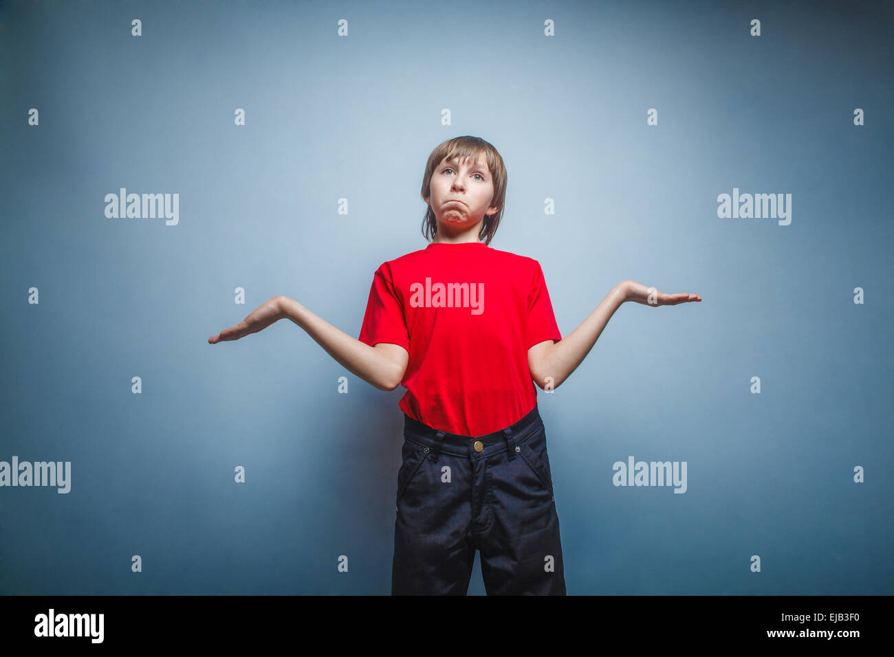 Garçon, adolescent, douze ans en rouge T-shirt, levé les bras au ciel, Banque D'Images