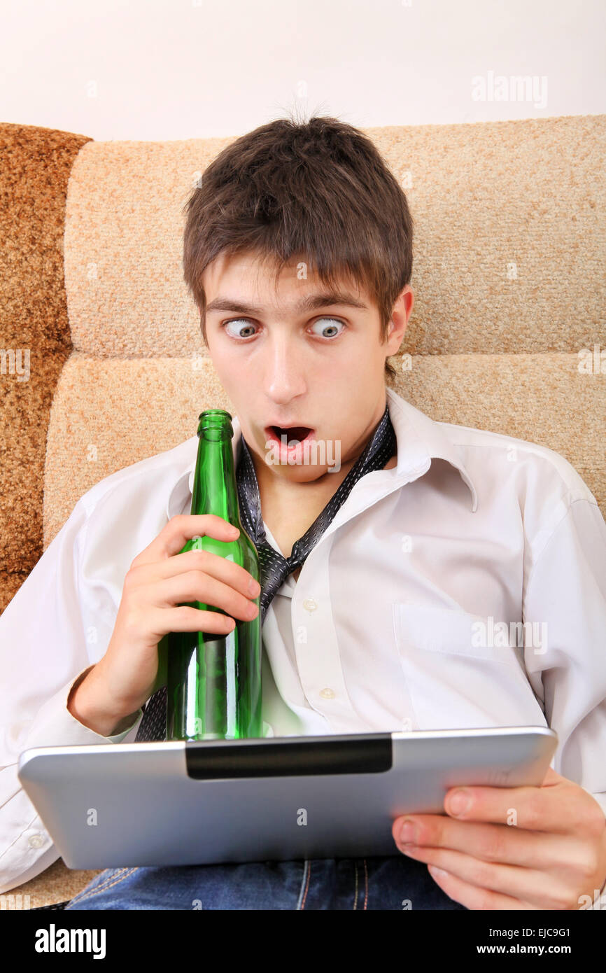 Adolescent avec une bière et tablette Banque D'Images