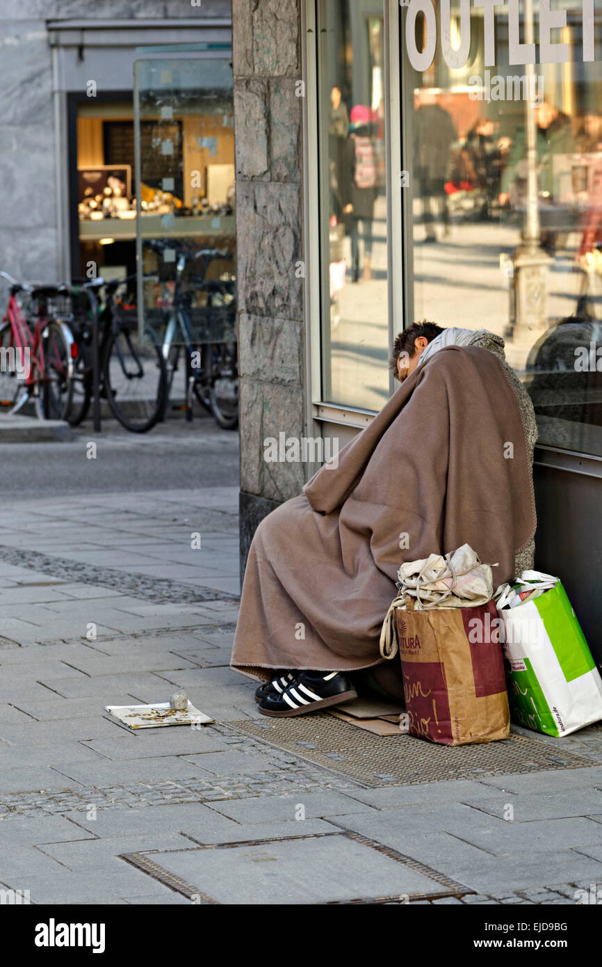 Un mendiant dormir contre vitrine, Munich, Haute-Bavière, Allemagne, Europe. Banque D'Images