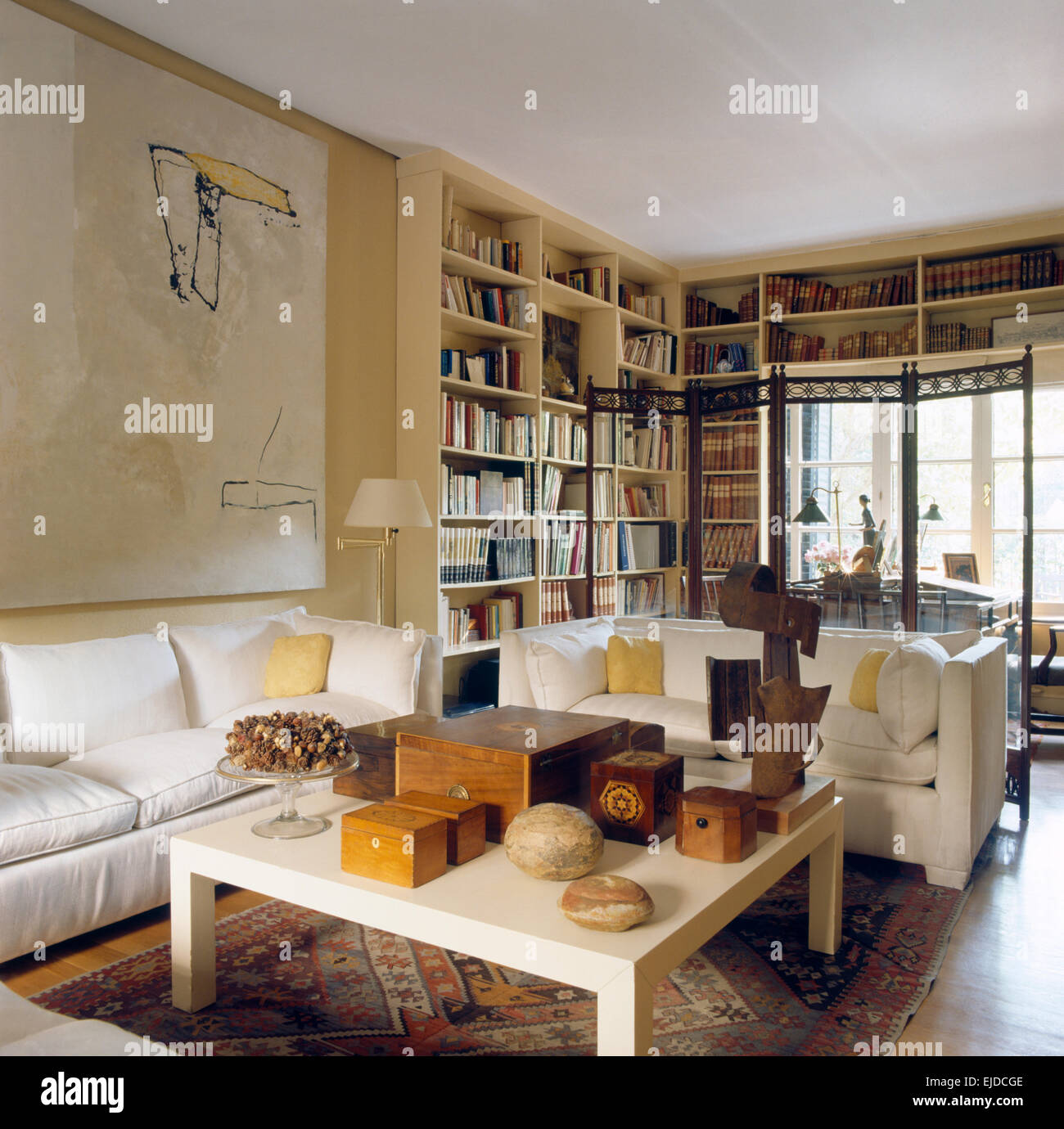 Canapés blancs et une table basse avec collection de meubles anciens, de  caisses en bois dans la salle de séjour conçu par Pablo Carvajal Photo  Stock - Alamy