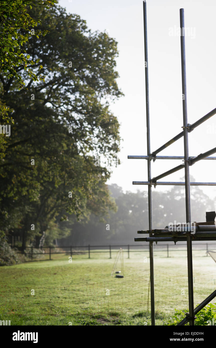 Les échafaudages sur le coin d'un bâtiment. Un petit filet de but de football dans un jardin. Banque D'Images