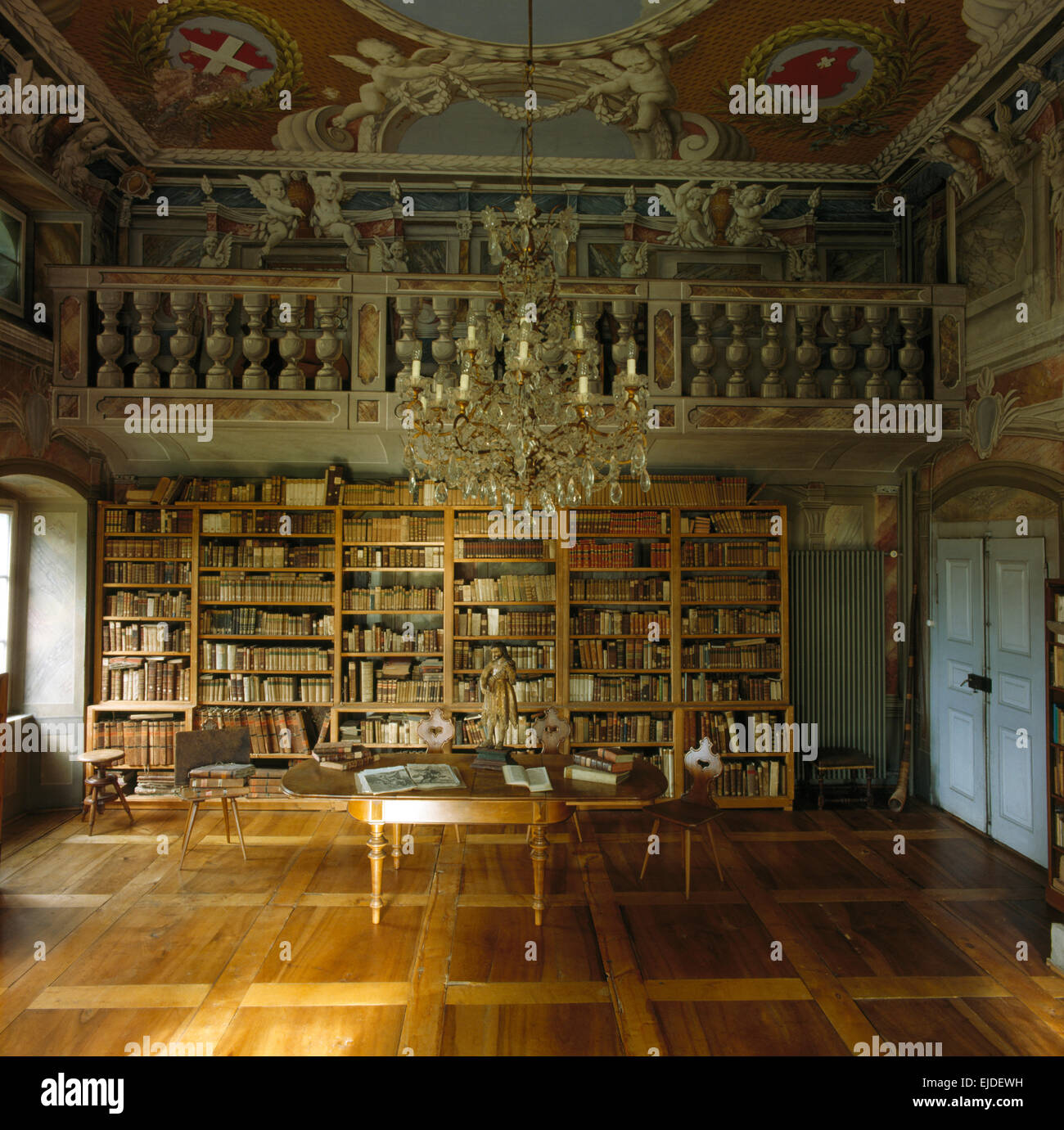 Lustre en verre de cristal antique demeure seigneuriale en étude avec ornately plafond peint et grande bibliothèque Banque D'Images