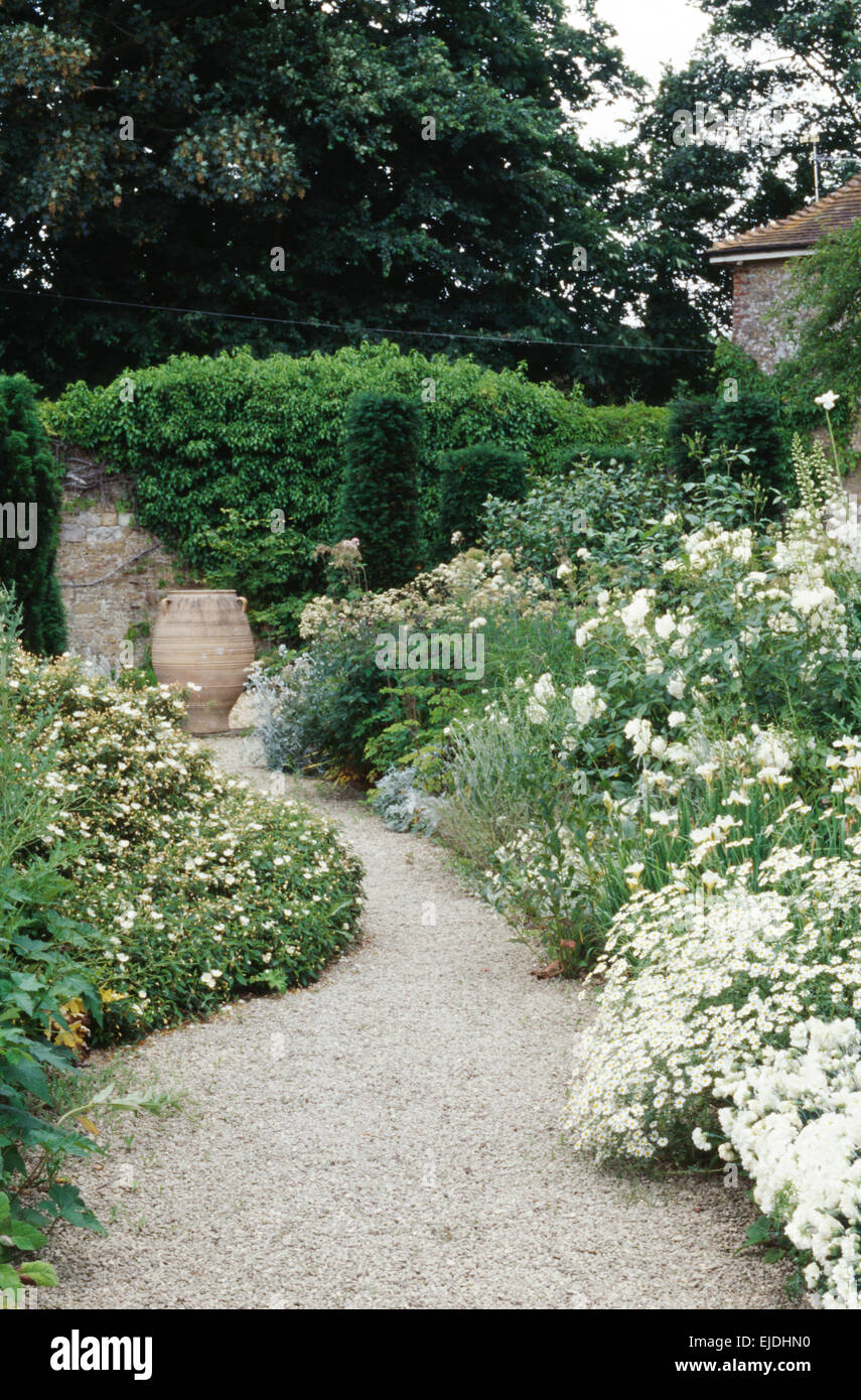 Chemin de gravier à travers des frontières avec tous les pays dans les grandes plantes blanc jardin en été Banque D'Images