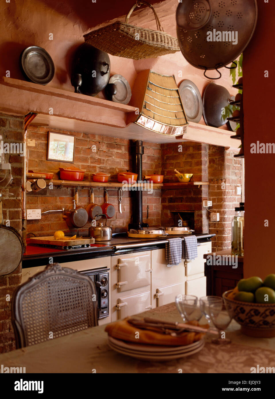 Double blanc cuisine Aga en chalet avec mur en briques apparentes Banque D'Images