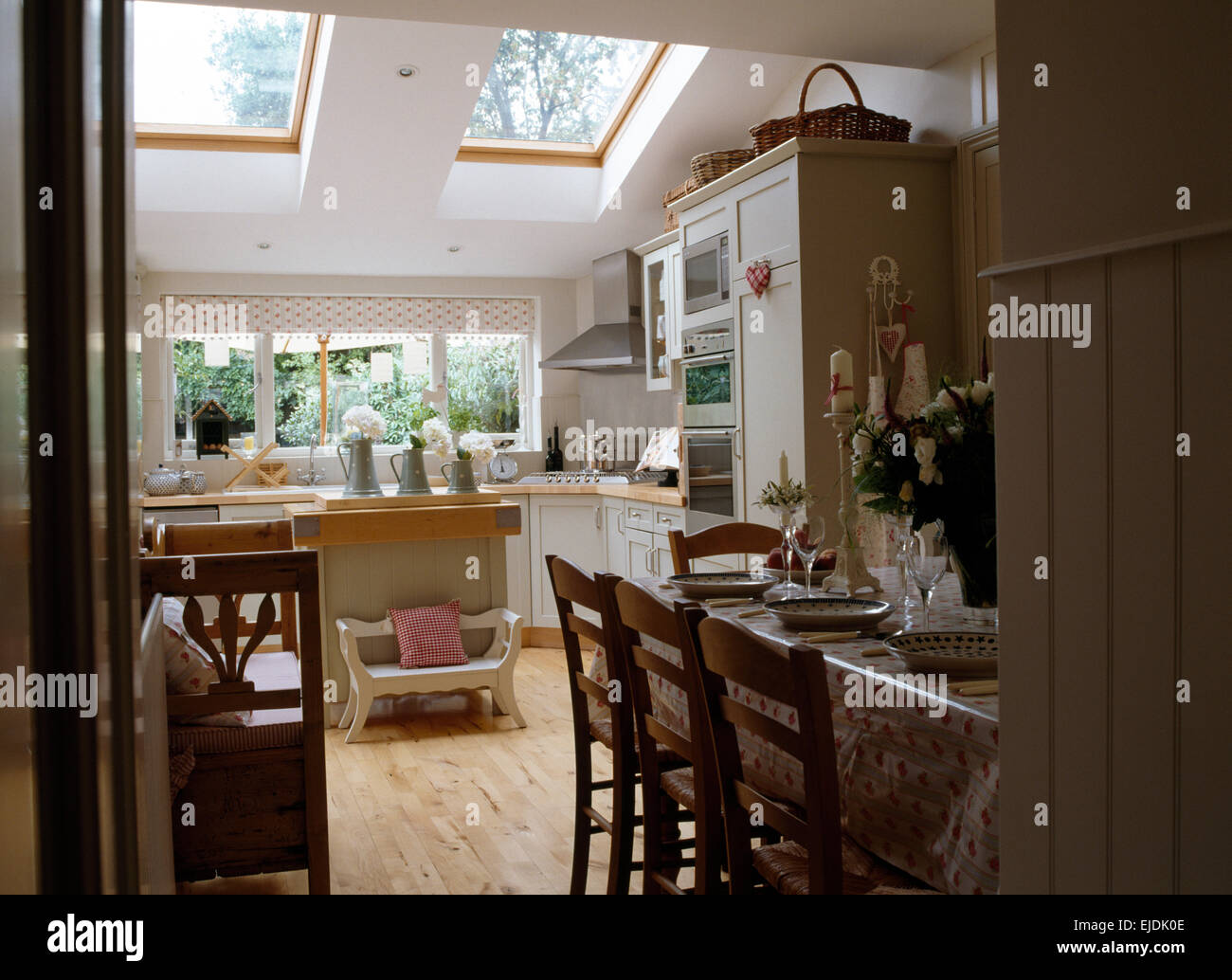 Vieilles chaises en bois à table avec en toile PVC coin repas de cuisine moderne extension Banque D'Images