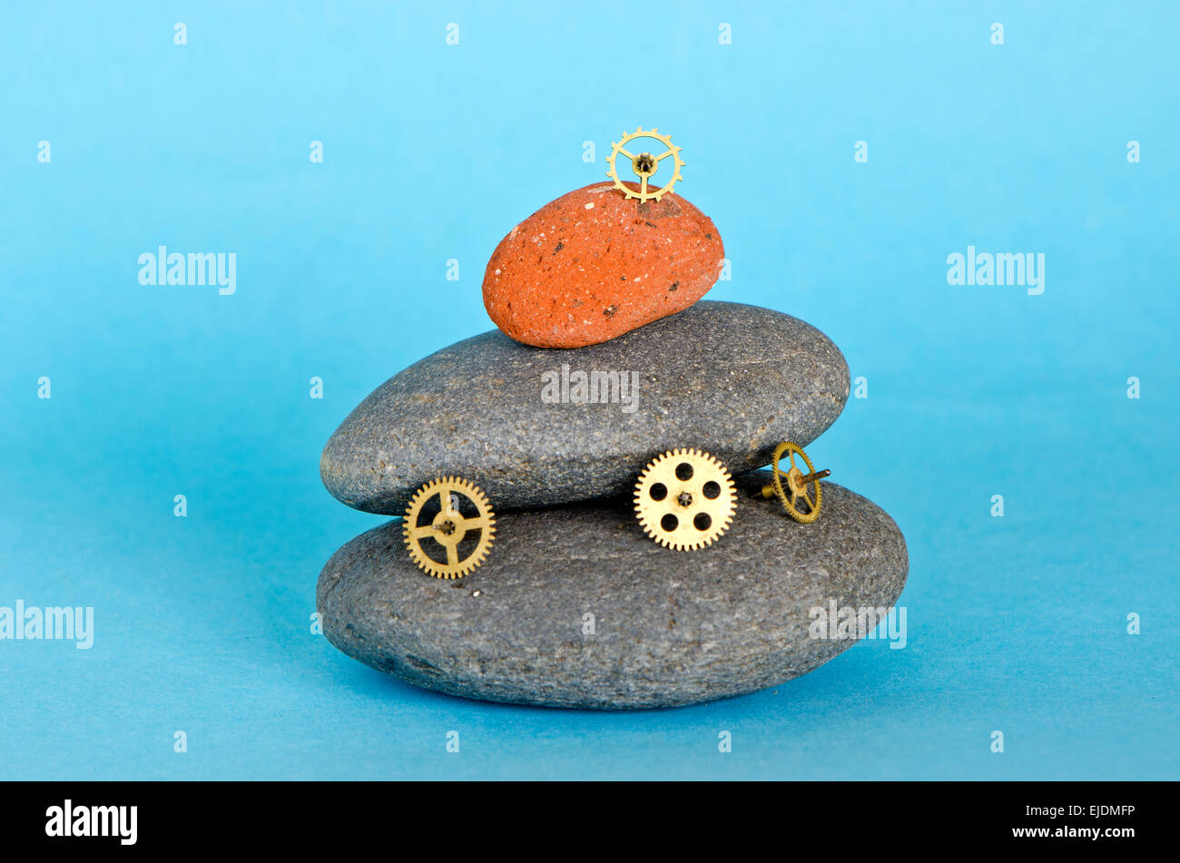 Belle mer pierre et mécanisme d'horloge engrenages en laiton sur fond bleu. Temps et concept de pierre Banque D'Images