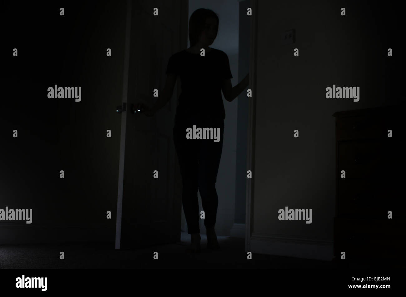 Silhouette méconnaissable d'une jeune fille debout dans une porte. Banque D'Images