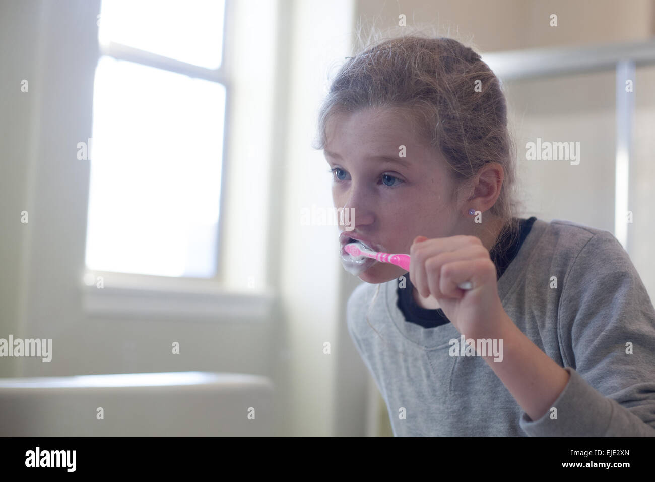 À la fille dans le miroir se brosser les dents Banque D'Images