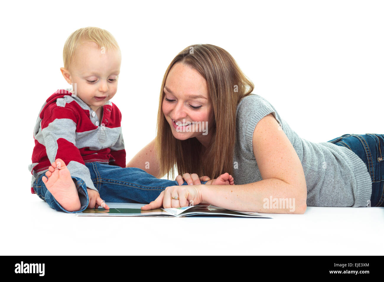 Smiling Mother and Baby Boy Reading Book Together isolées sur fond blanc Banque D'Images