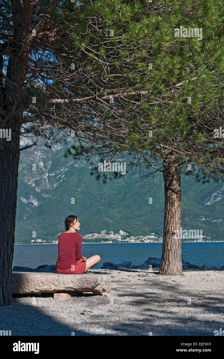 Femme assise à la rive à Limone au Lac de Garde en Italie du nord Banque D'Images