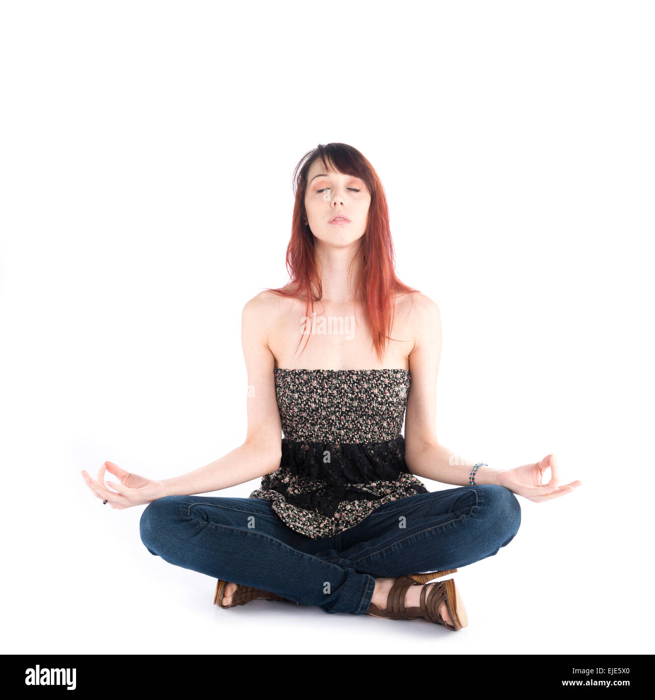 Jeune femme assise en Yoga Pose les yeux fermés Banque D'Images