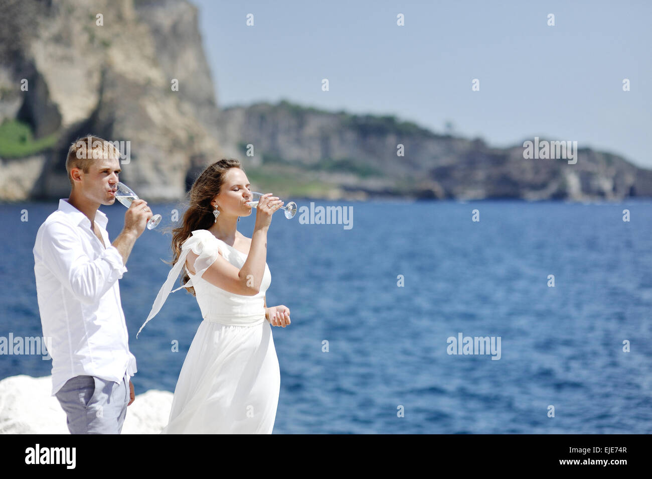 Jeune couple drinking champagne in mariage près de mer de Naples, Italie Banque D'Images
