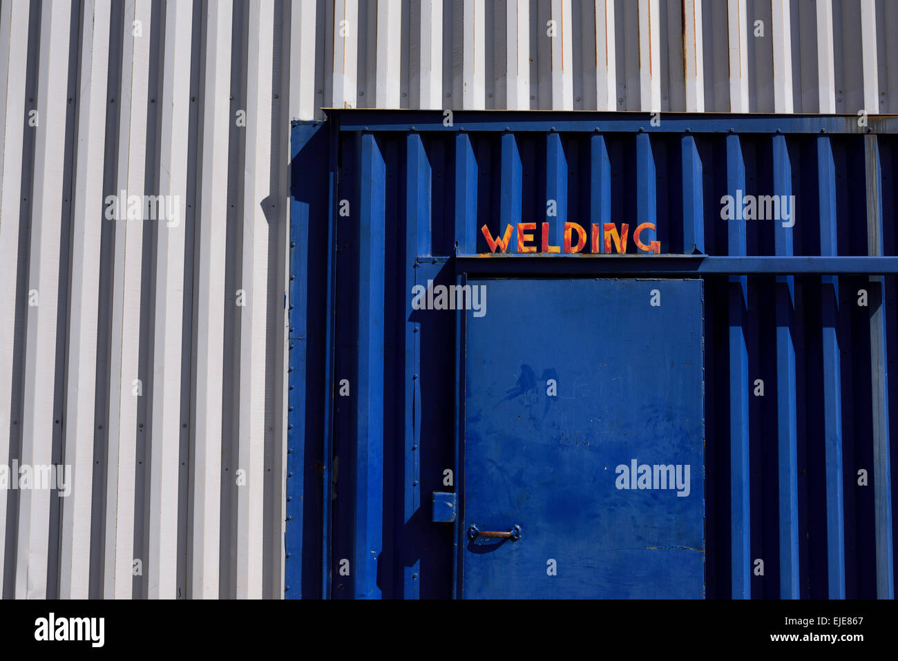 Porte bleue à un atelier de soudure en métal ondulé rouge signe de soudage avec Toronto Banque D'Images