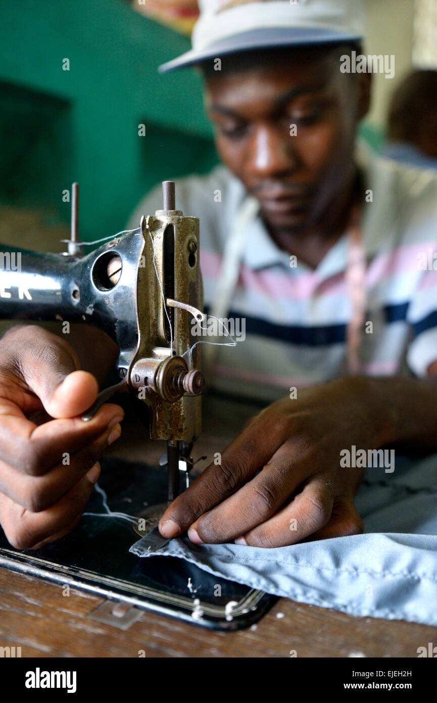 Jeune homme travaillant sur une machine à coudre couture d'apprentissage l'artisanat, l'adaptation de l'école Missions Salésiennes Banque D'Images
