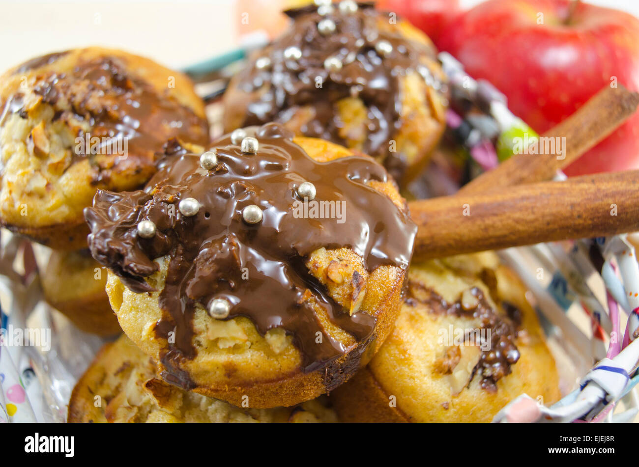 Bouquet de délicieux muffins au chocolat dans un papier fait à la main panier décoré avec des bâtons de cannelle et de pommes Banque D'Images