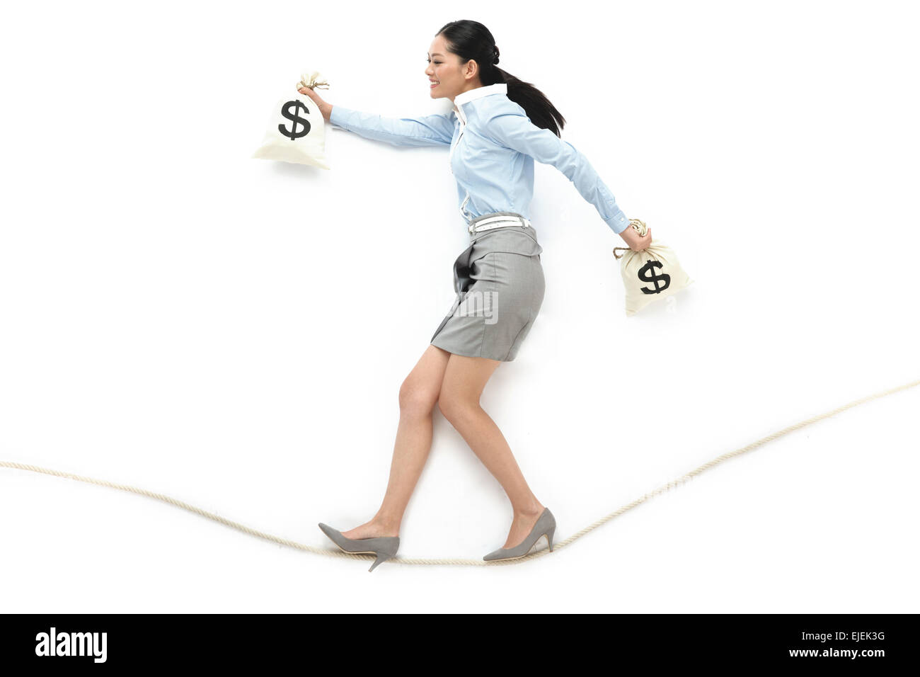 Business Woman holding un sac à main sur une corde raide Banque D'Images