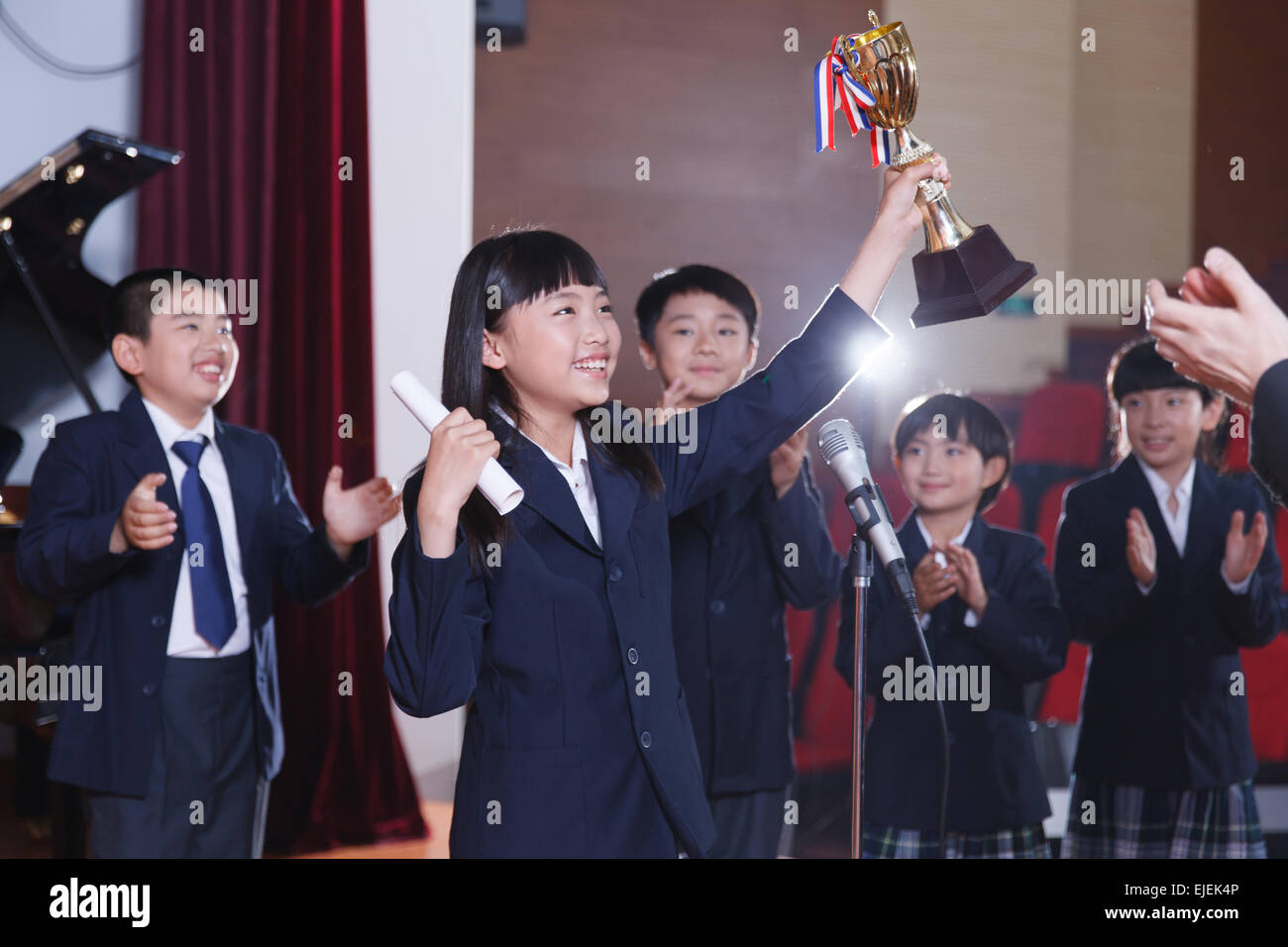 Les élèves enthousiastes agitant tient un trophée d'armes Banque D'Images