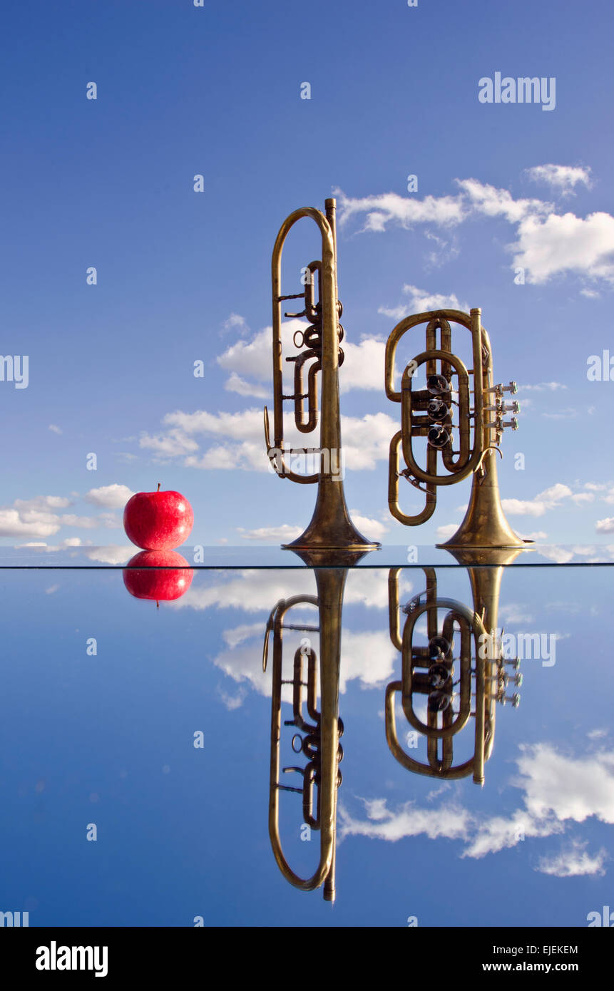 Instruments de musique en laiton rétro sur miroir dans l'espace et pomme fruit rouge Banque D'Images