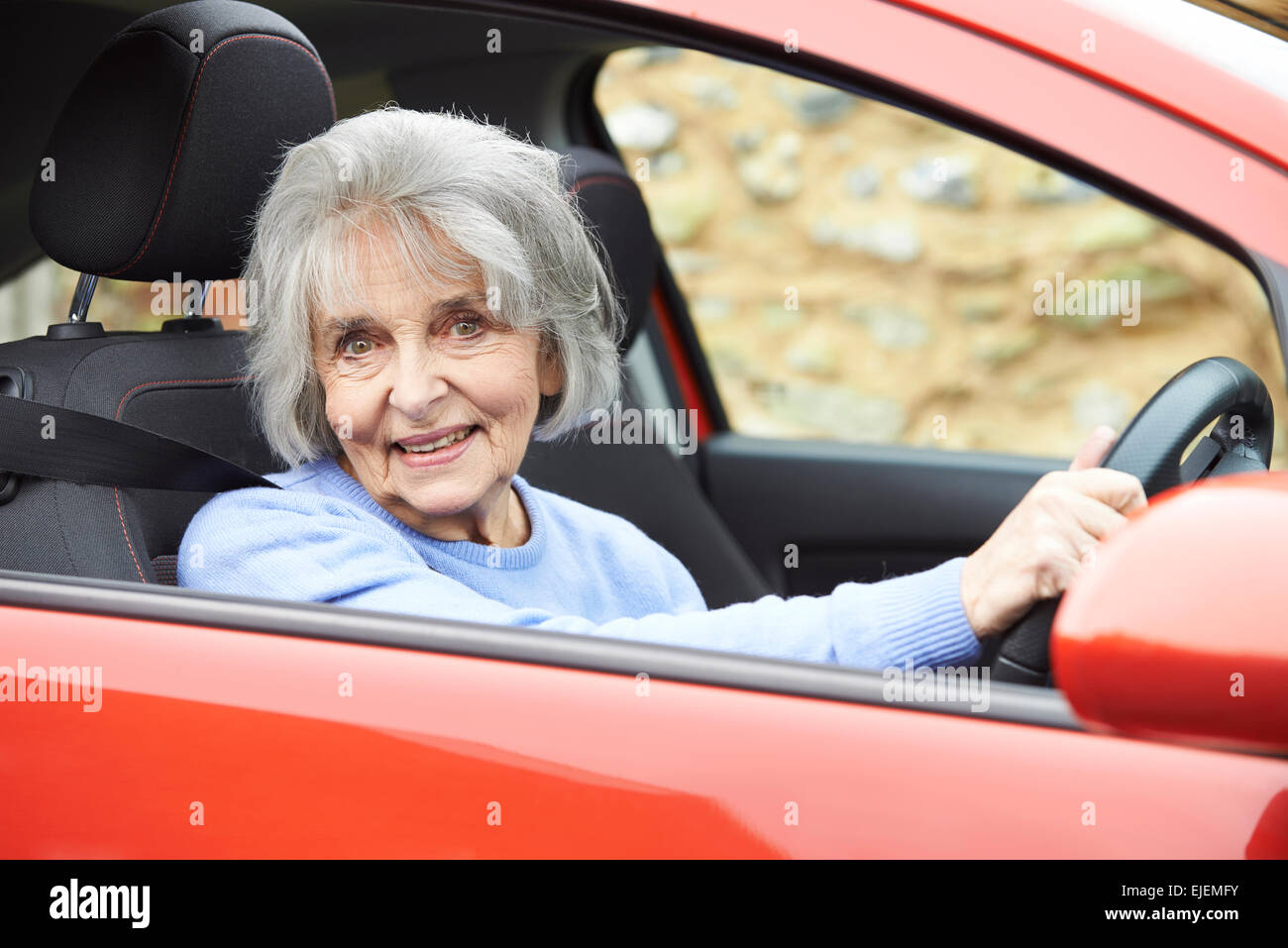Portrait Of Smiling Senior Woman Driving Car Banque D'Images