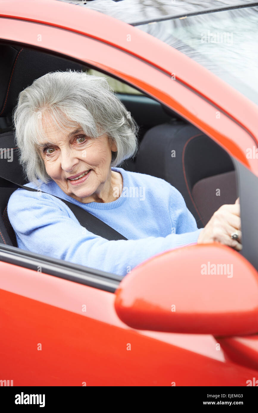 Portrait Of Smiling Senior Woman Driving Car Banque D'Images
