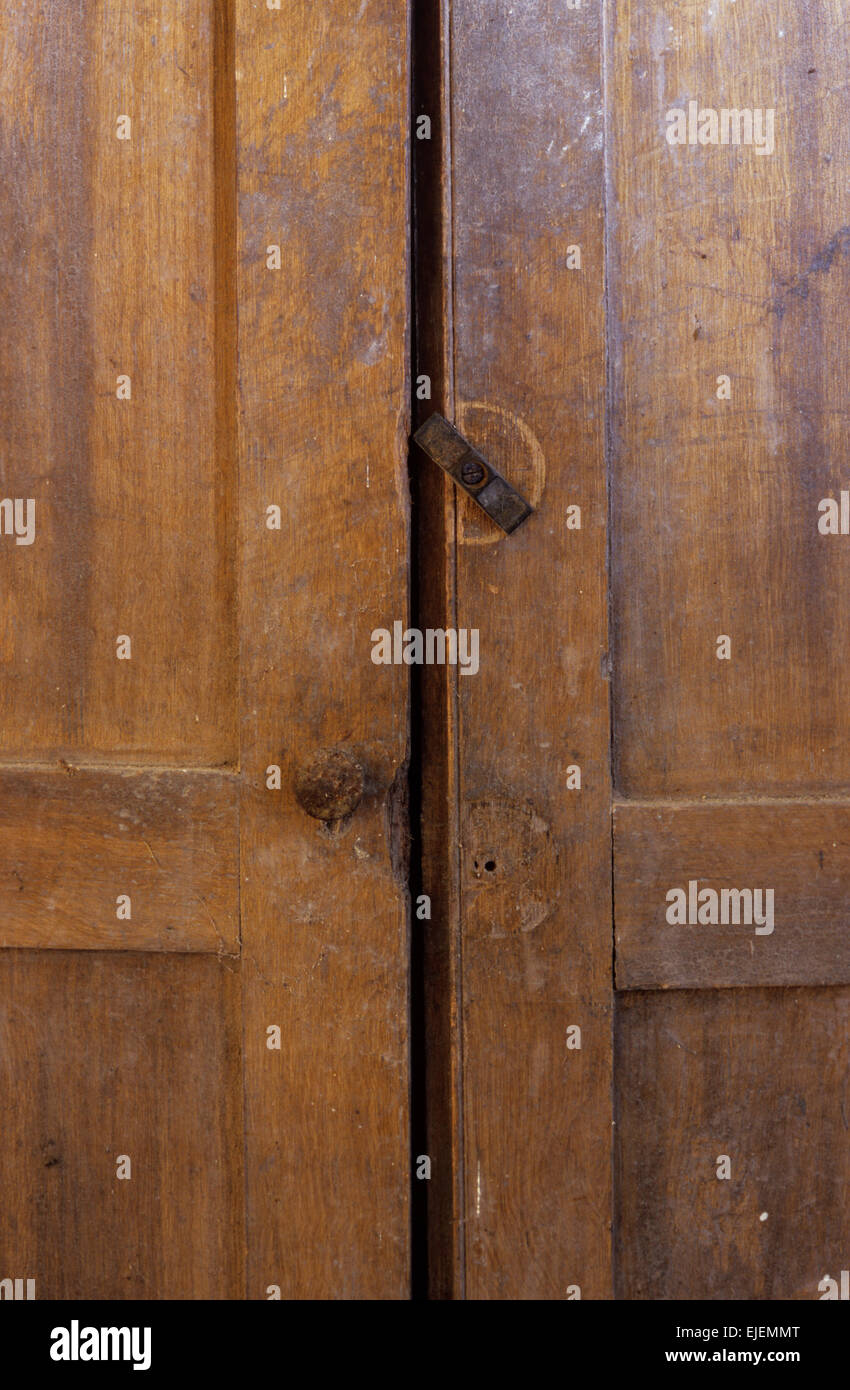 Détail des portes de la vieille armoire en bois marron avec une seule poignée manquante et beaucoup d'usage à prendre Banque D'Images