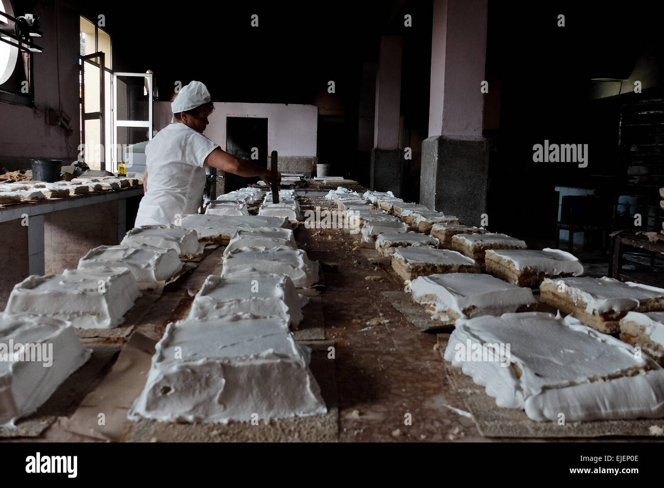 Une femme décore des gâteaux dans une boulangerie dans les 500 ans de la  ville de Sancti Spiritus, Cuba. La grande majorité des Cubains sont des  employés du gouvernement comme la plupart