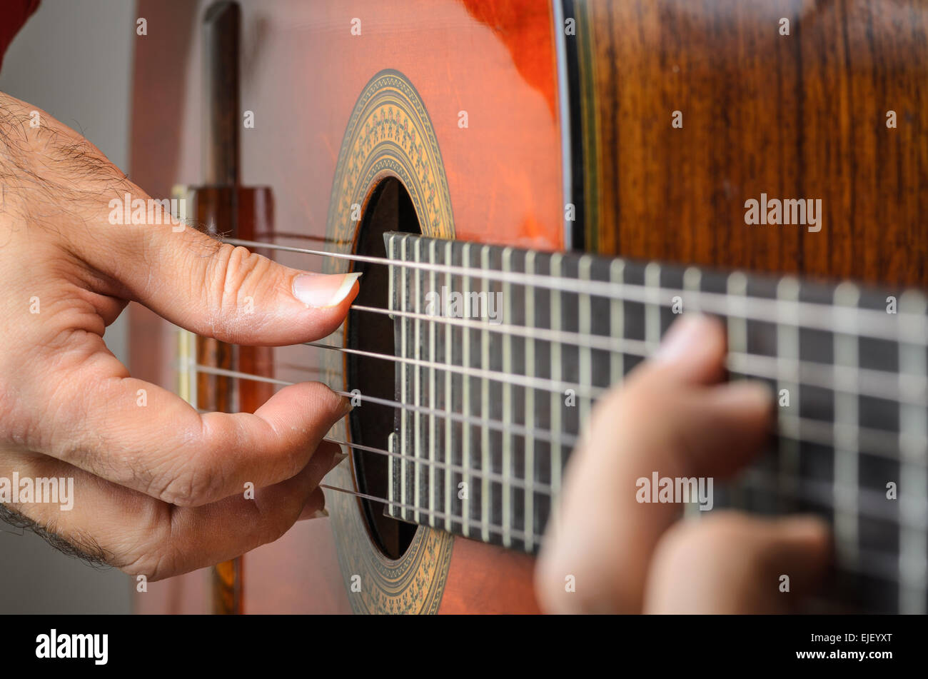 Gros plan des mains de l'homme jouant de la guitare classique rouge, se  concentrer sur les doigts de la main droite avec les clous dans une position  Photo Stock - Alamy