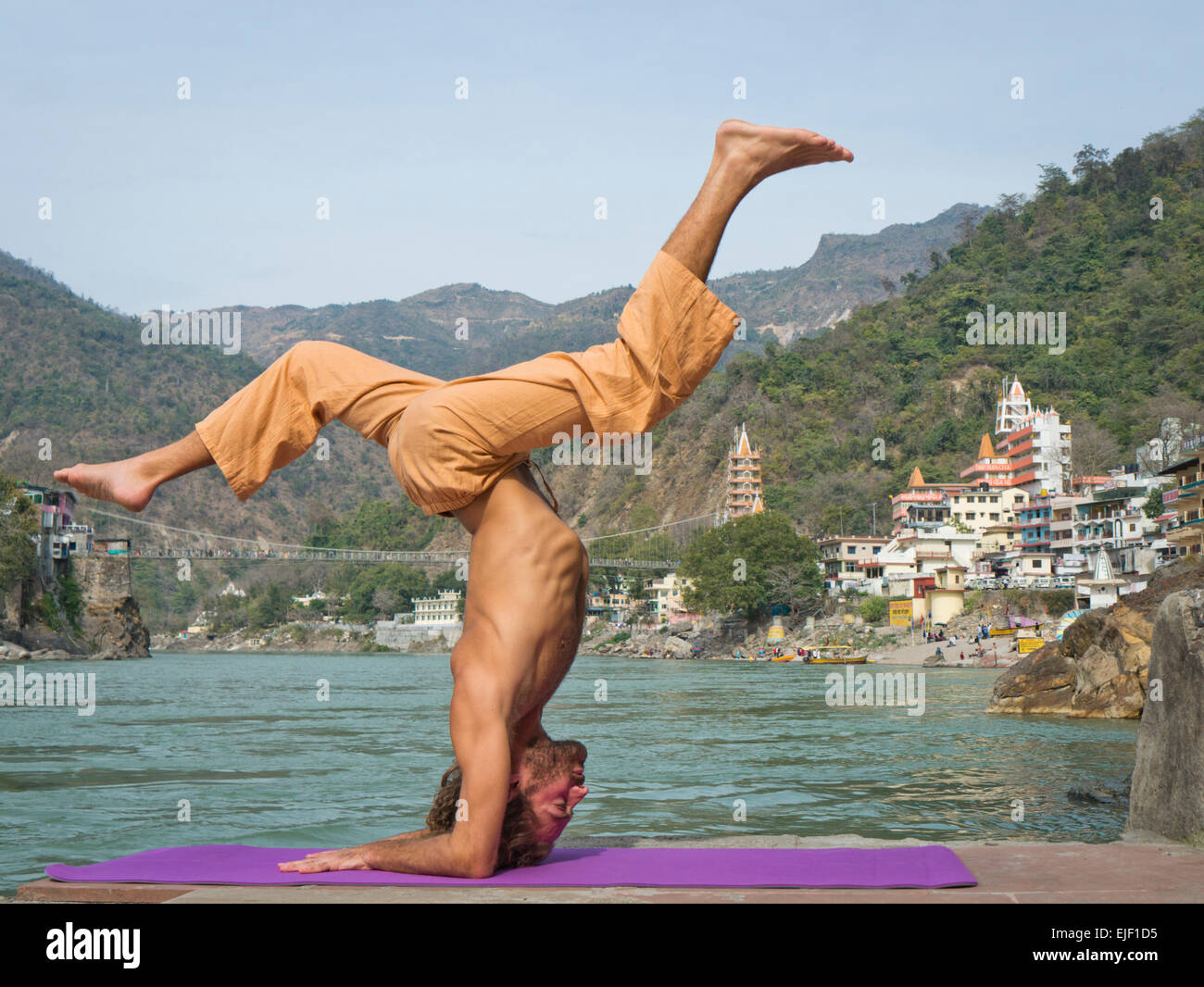 Un homme pratiquant le yoga par le Gange à Rishikesh Inde Banque D'Images