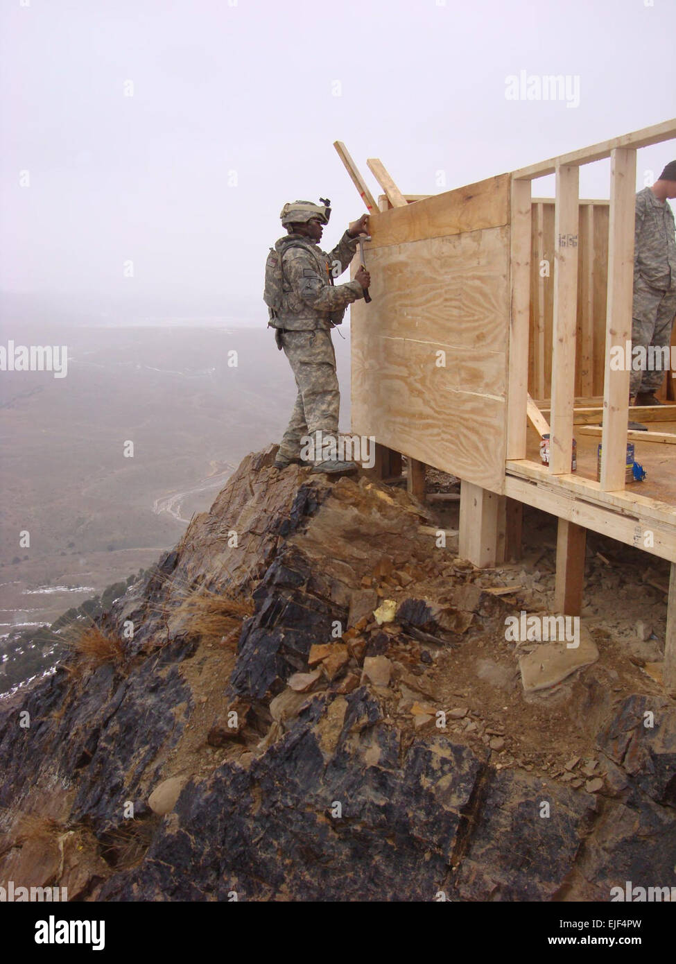 Le sergent de l'armée. Carlos Bell, la Compagnie Bravo du 864e bataillon du  génie, Fort Lewis, Washington, ongles le mur d'un bunker à un avant-poste  au milieu d'une montagne de l'Afghanistan Photo