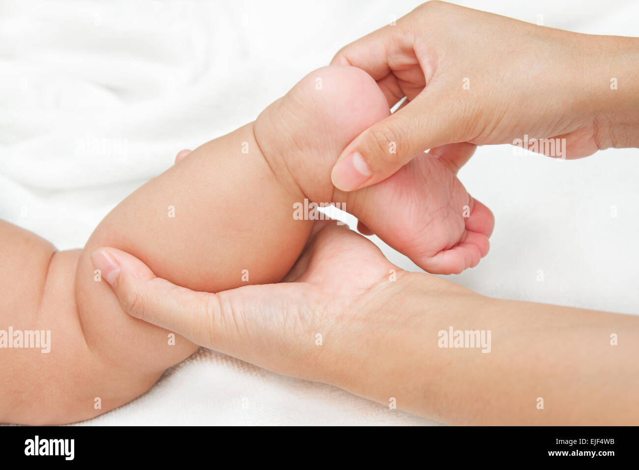 Mère working jambe et le muscle du pied de son bébé,touche de bonheur Banque D'Images