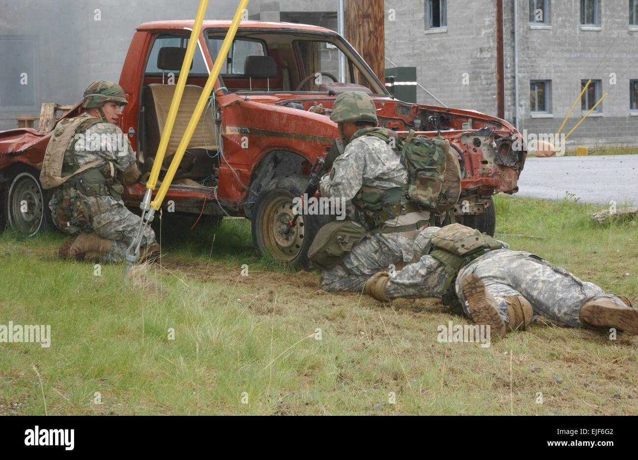 Un soldat de l'armée américaine et deux scouts de 5e Escadron, 1e régiment de cavalerie se cacher derrière une voiture tout en établissant une stratégie pour récupérer un soldat blessé dans la ligne de tir au cours de l'expert infantryman badge compétition à Fort Wainwright, Alaska, le 1 août 2007. La CPS. L. Tiffany Evans publié Banque D'Images