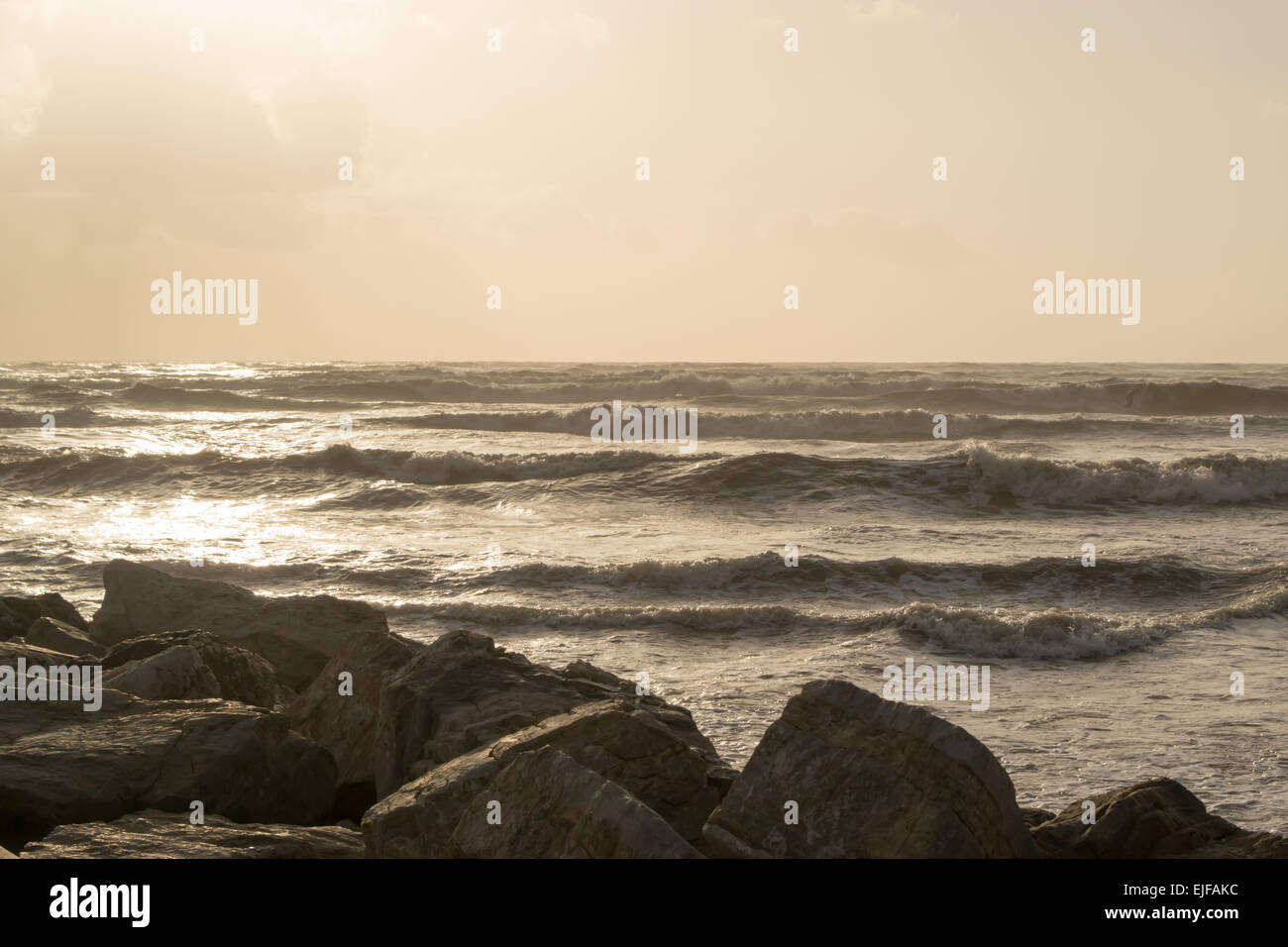 Une plage déserte avec le fracas des vagues et la roche d'une légère teinte sépia Noir et blanc. Banque D'Images