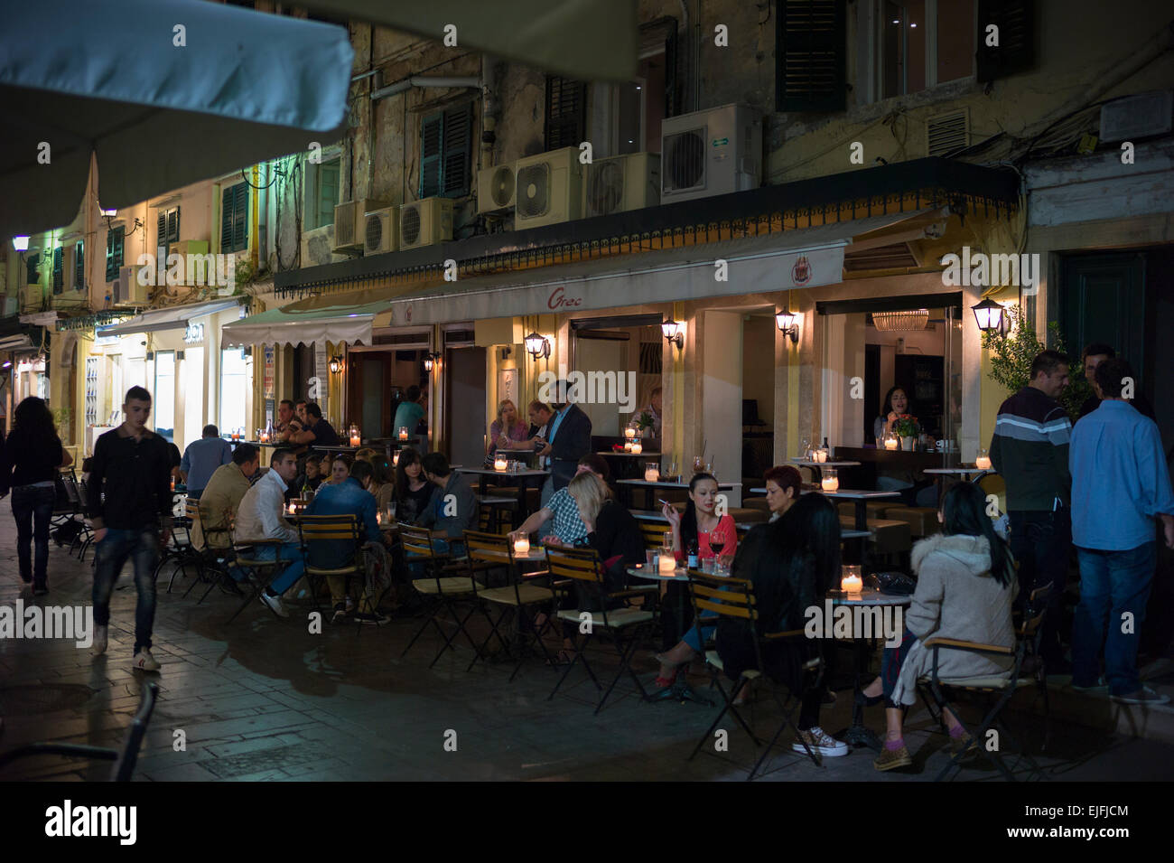 La société Café de Nuit Scène de rue, la population locale et les touristes à pavement cafe bar restaurant à Kerkyra, Corfou, Grèce Banque D'Images