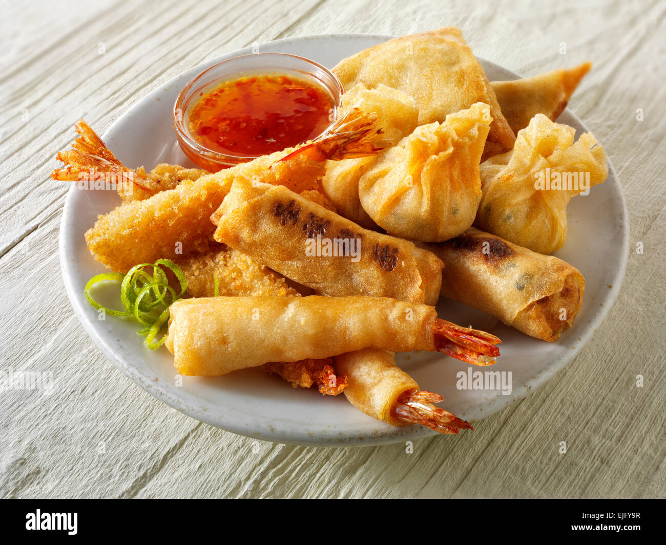 Démarreurs - Chinois mixte cuite dim sum, crevettes panées, rouleaux de printemps avec sauce chili servi sur une plaque blanche Banque D'Images