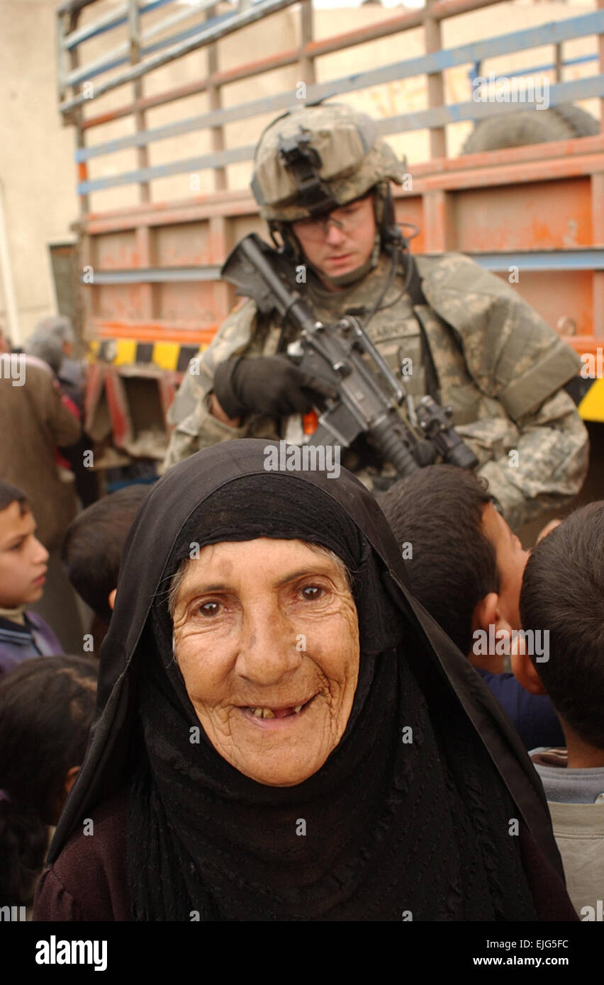 Une femme âgée sourit comme des soldats de l'Armée américaine à partir de la troupe, 4e Escadron, 9e régiment de cavalerie, 2e Brigade Combat Team, 1re Division de cavalerie la prestation de l'aide sur la rue Haïfa à Bagdad, l'Iraq, le 13 février 2007. La CPS. Olanrewaju Akinwunmi Banque D'Images