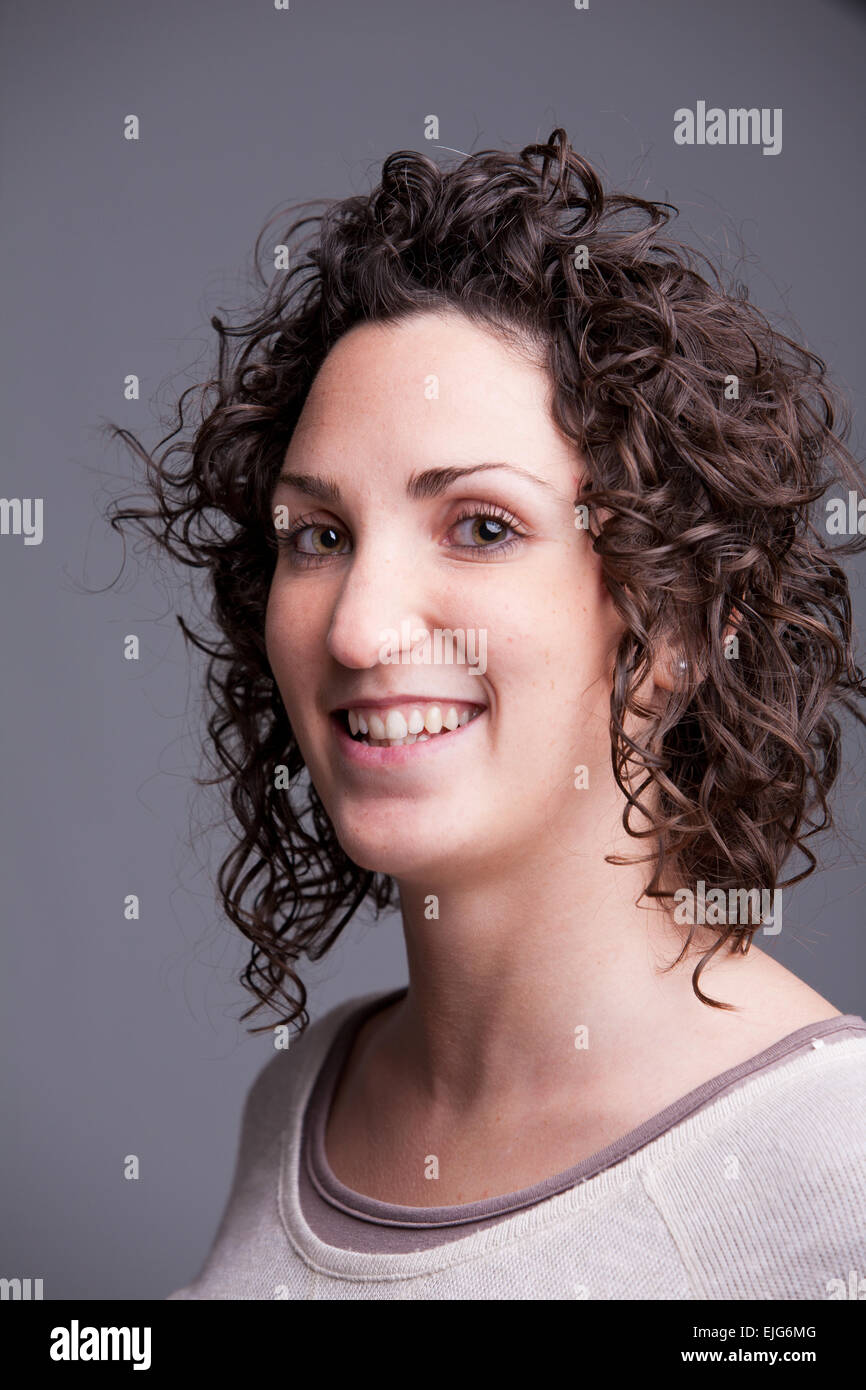 Premier plan, Portrait of a smiling curly haired femme européenne Banque D'Images