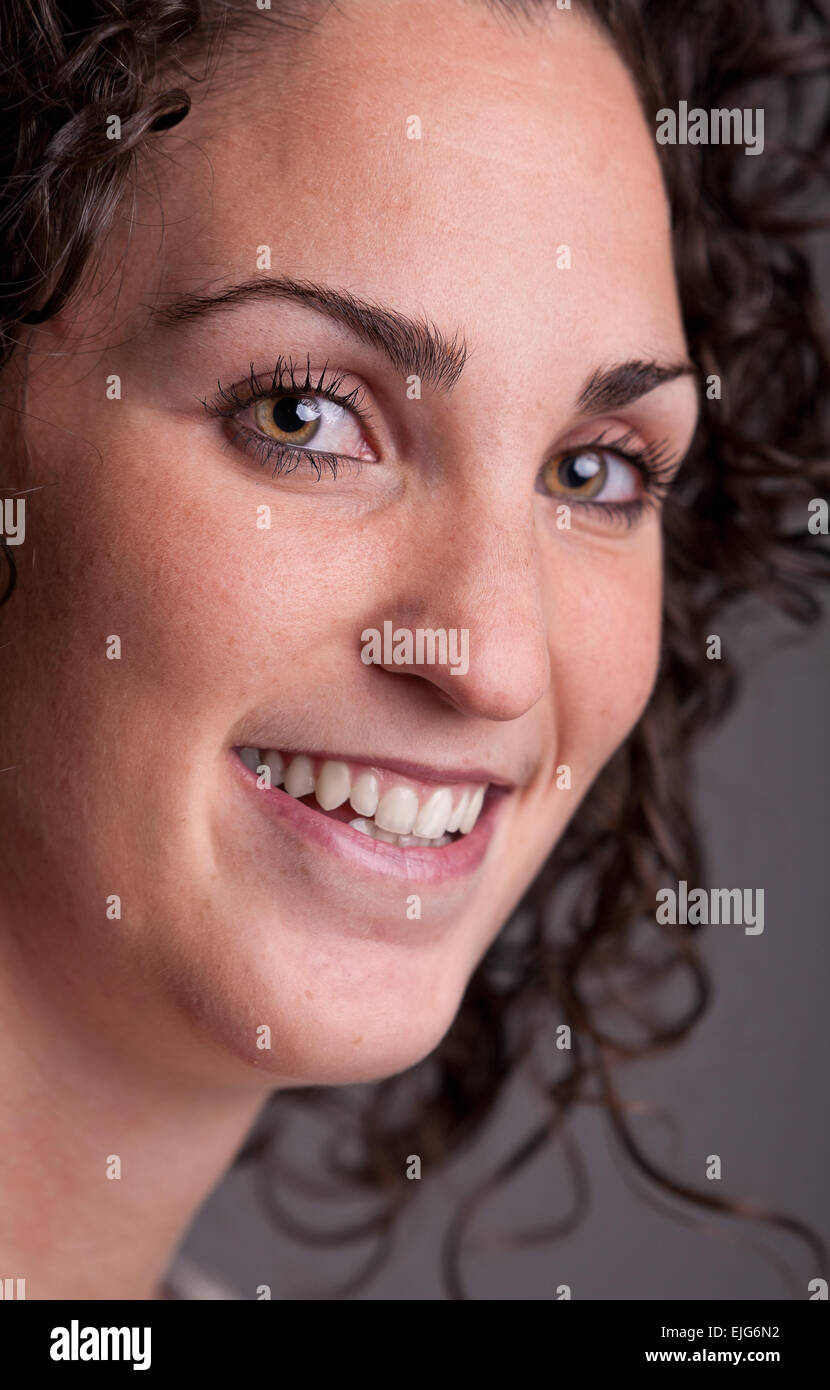 Premier plan, Portrait of a smiling curly haired femme européenne Banque D'Images