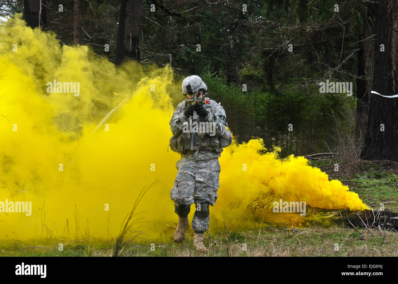 JOINT BASE LEWIS McCHORD-, Washington - Un soldat de la compagnie G, 52e Régiment d'infanterie, 4e Stryker Brigade Combat Team, 2e Division d'infanterie, émerge de la dissimulation de la fumée de couleur à l'assaut d'une position de l'ennemi supprimées pendant une squad réagir à contacter percer Mar. 5. G/52 est une force de réserve pour stateside 4/2 SBCT et, sur commande, peut déployer une force aussi petites qu'un soldat ou aussi grand que l'ensemble de l'entreprise pour renforcer sa brigade parent en Afghanistan. La CPS. Loren Cook/relâché Banque D'Images