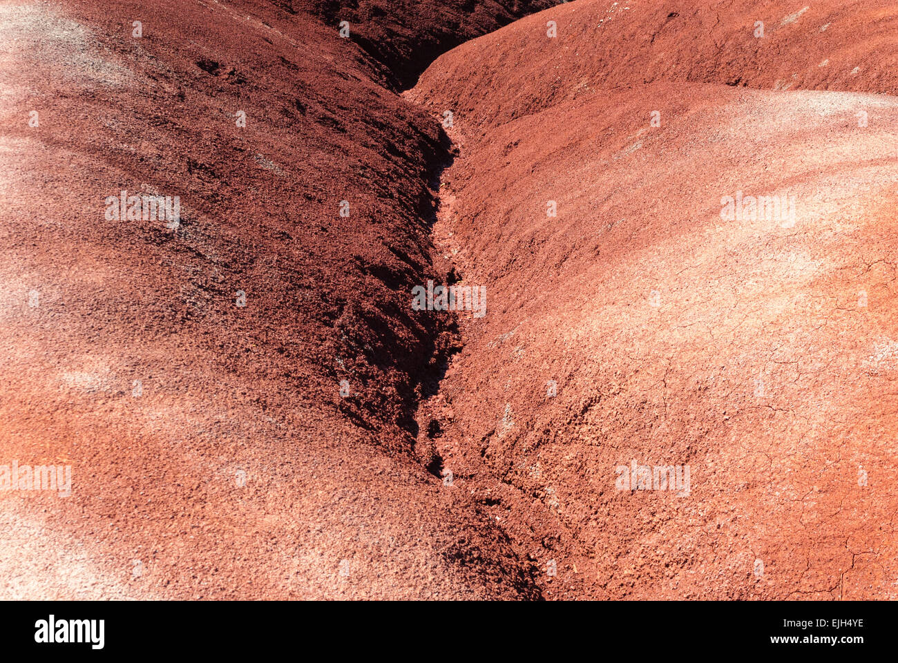 Canal d'eau entre l'érosion de l'argile rouge dunes badlands. Banque D'Images