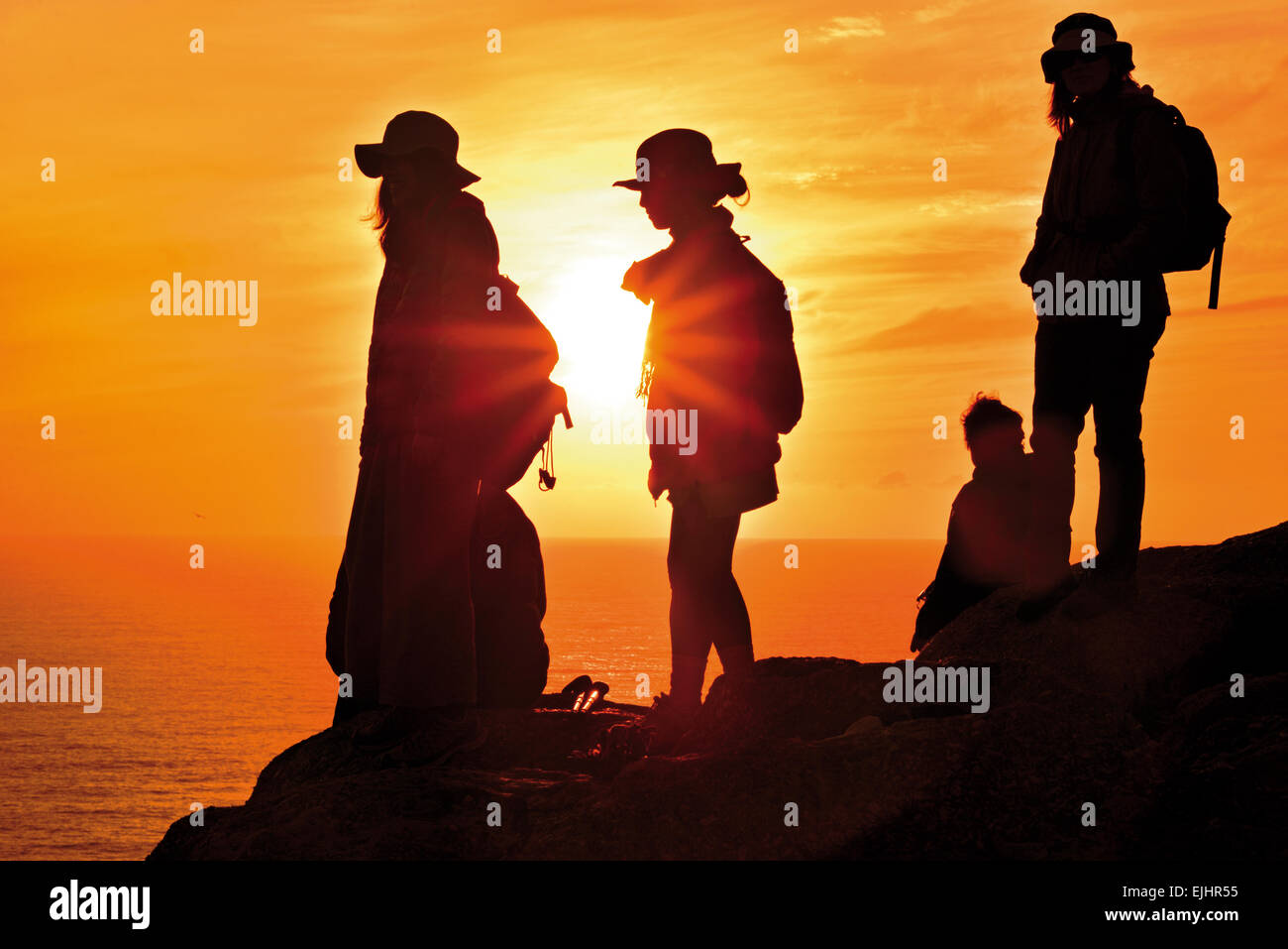 L'Espagne, la Galice : groupe de pèlerins de Saint-Jacques bénéficiant scenic sundown au Cap Fisterra Banque D'Images