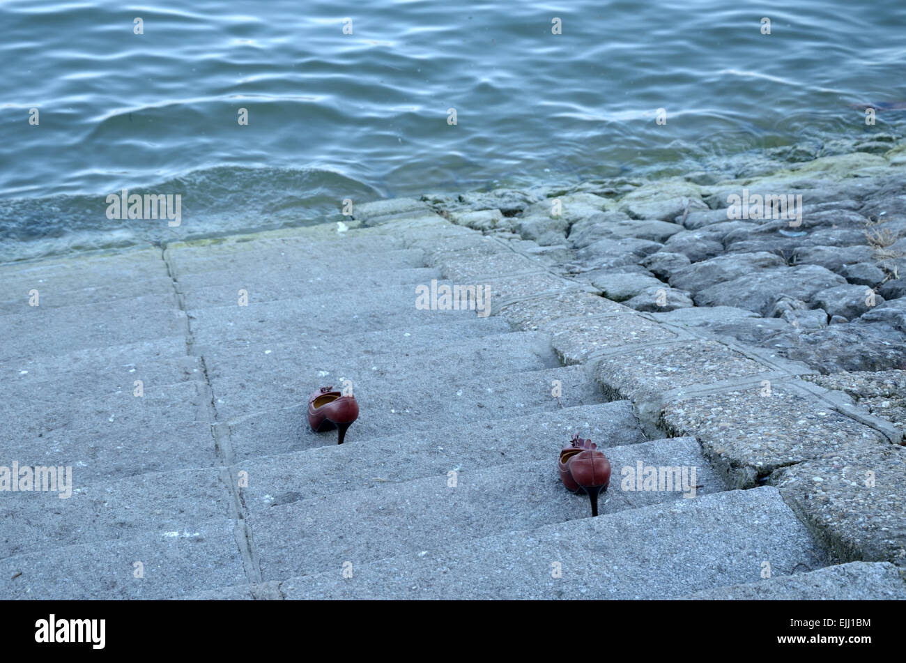 Chaussures pour femme sur les marches en pierre vont à la rivière. Banque D'Images
