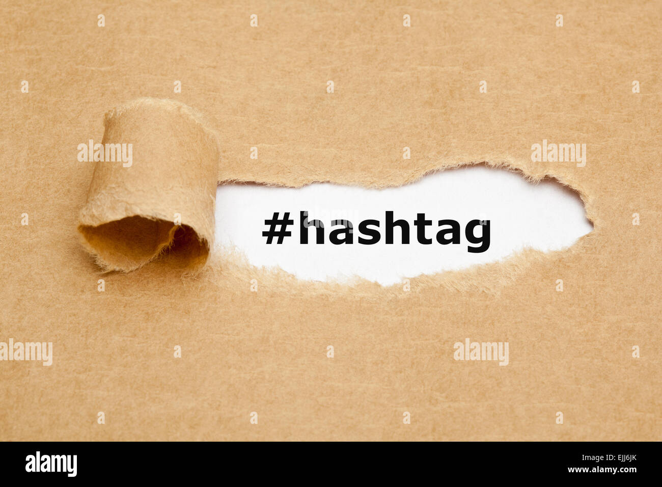 Le mot Hashtag apparaître derrière déchiré papier brun. Banque D'Images