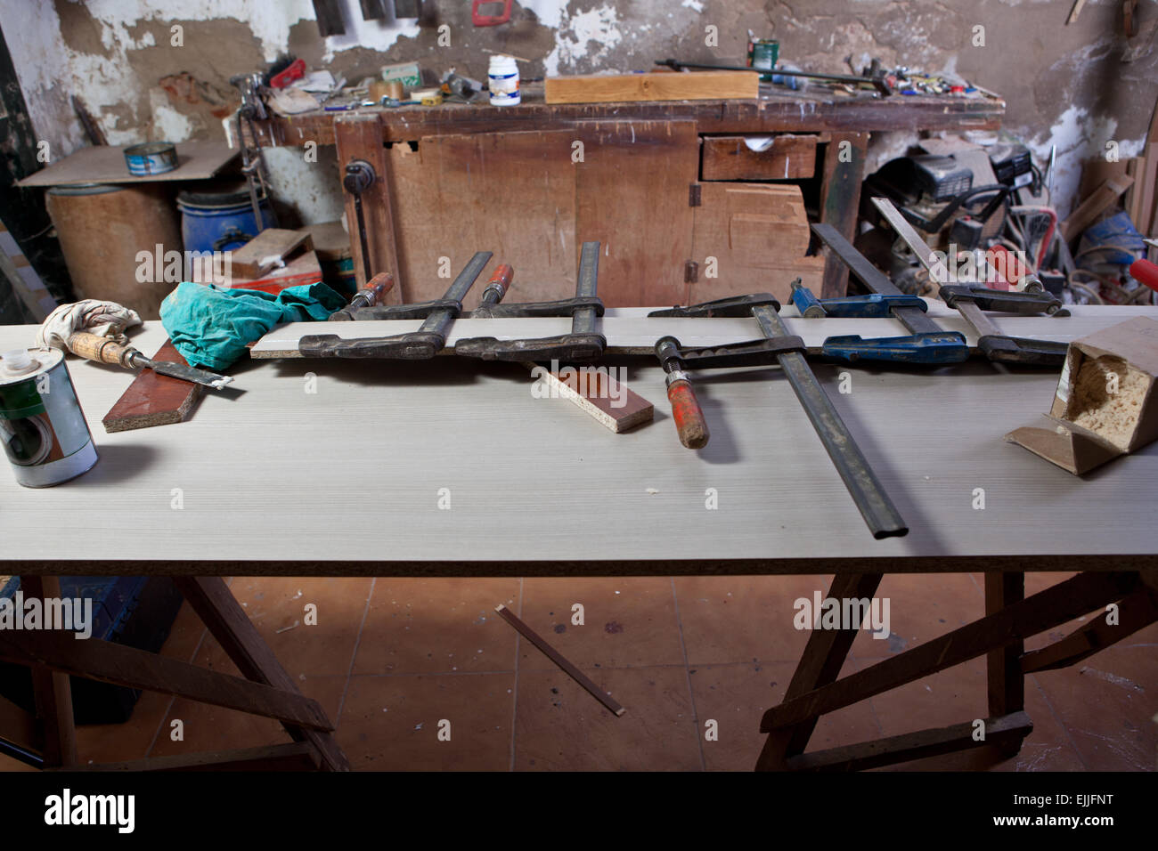 Ancien atelier de charpentier poussiéreux avec une table pleine de colliers Banque D'Images