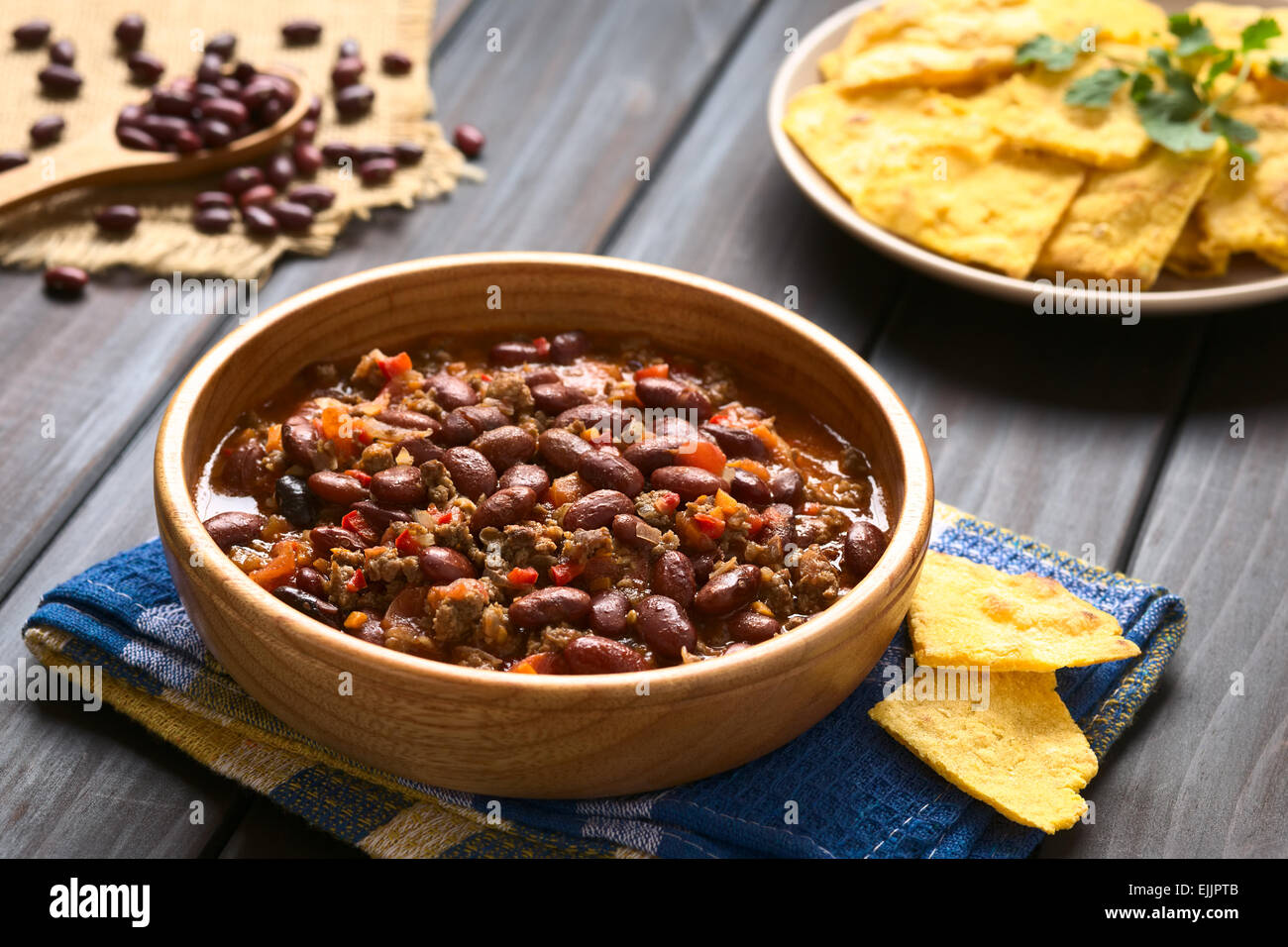 Bol en bois de chili con carne avec des croustilles à l'arrière, photographié avec une lumière naturelle (Selective Focus) Banque D'Images