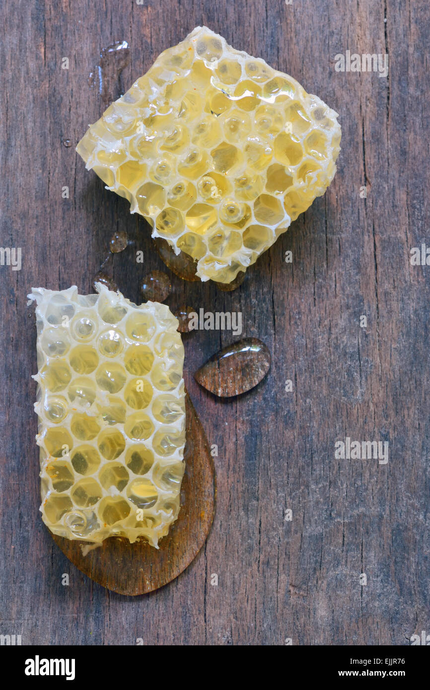 Gouttes de miel et d'abeilles plus vieille table en bois Banque D'Images