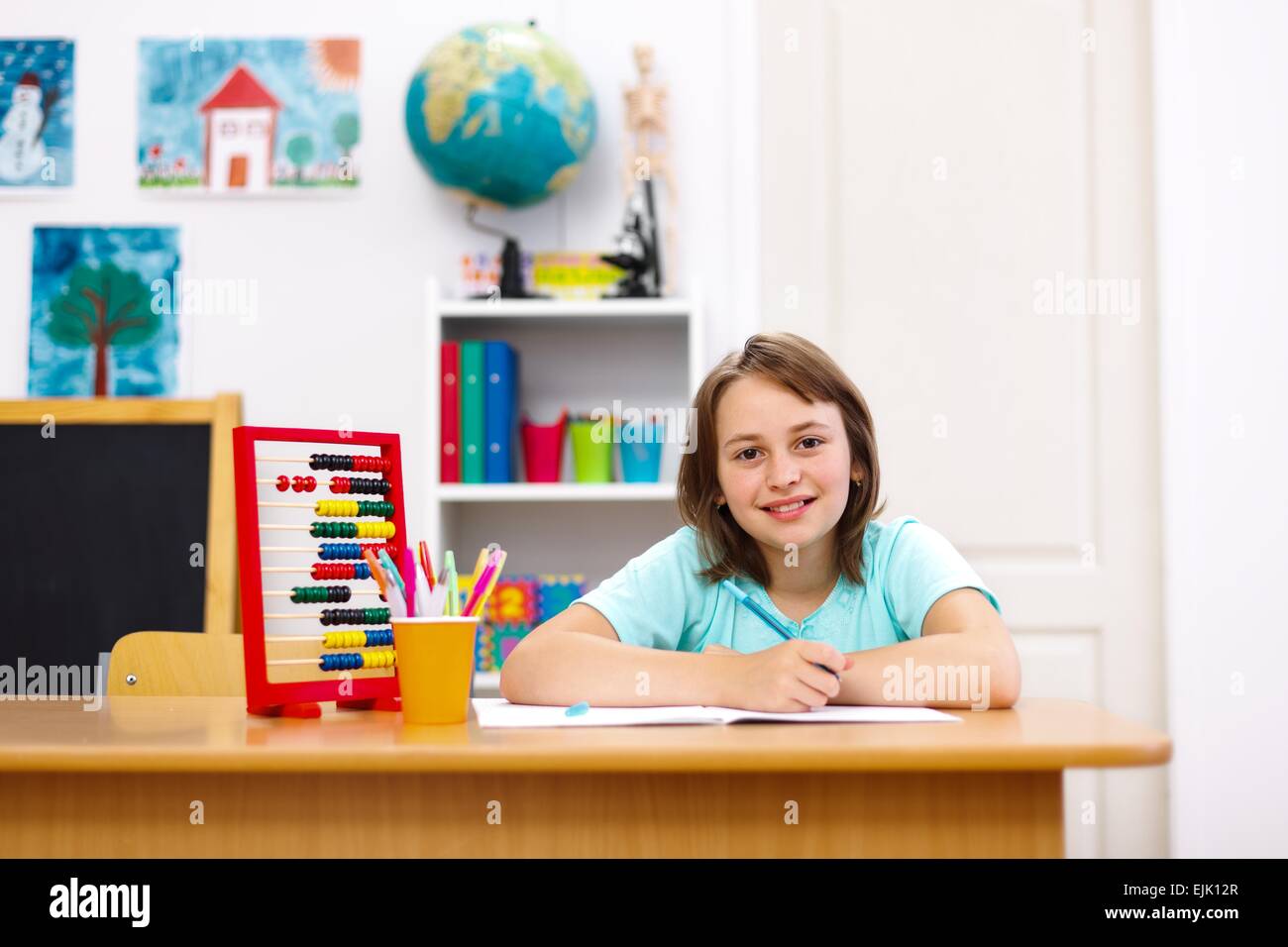 Cute schoolgirl pratiquer et faire des devoirs en classe Banque D'Images