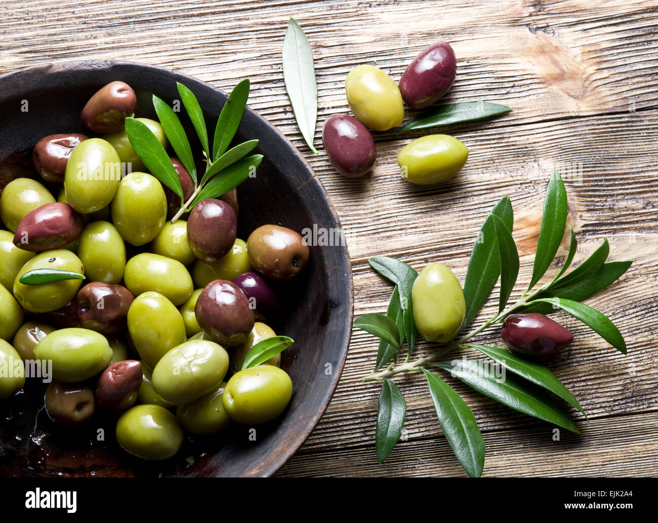 Bol en bois plein d'olives et les brindilles. Banque D'Images