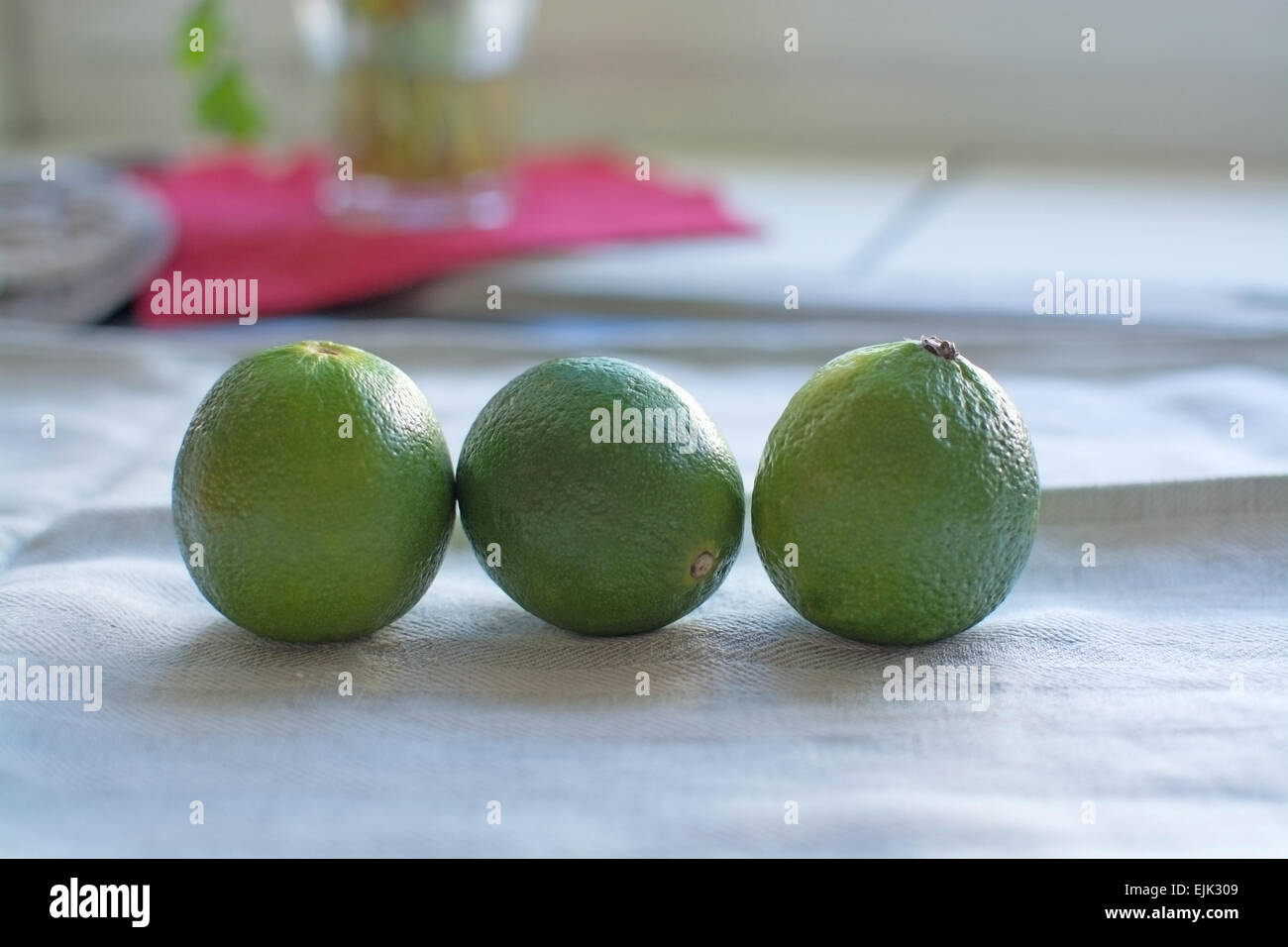 Trois fruits de la chaux dans une rangée sur le linge absorbant. Banque D'Images