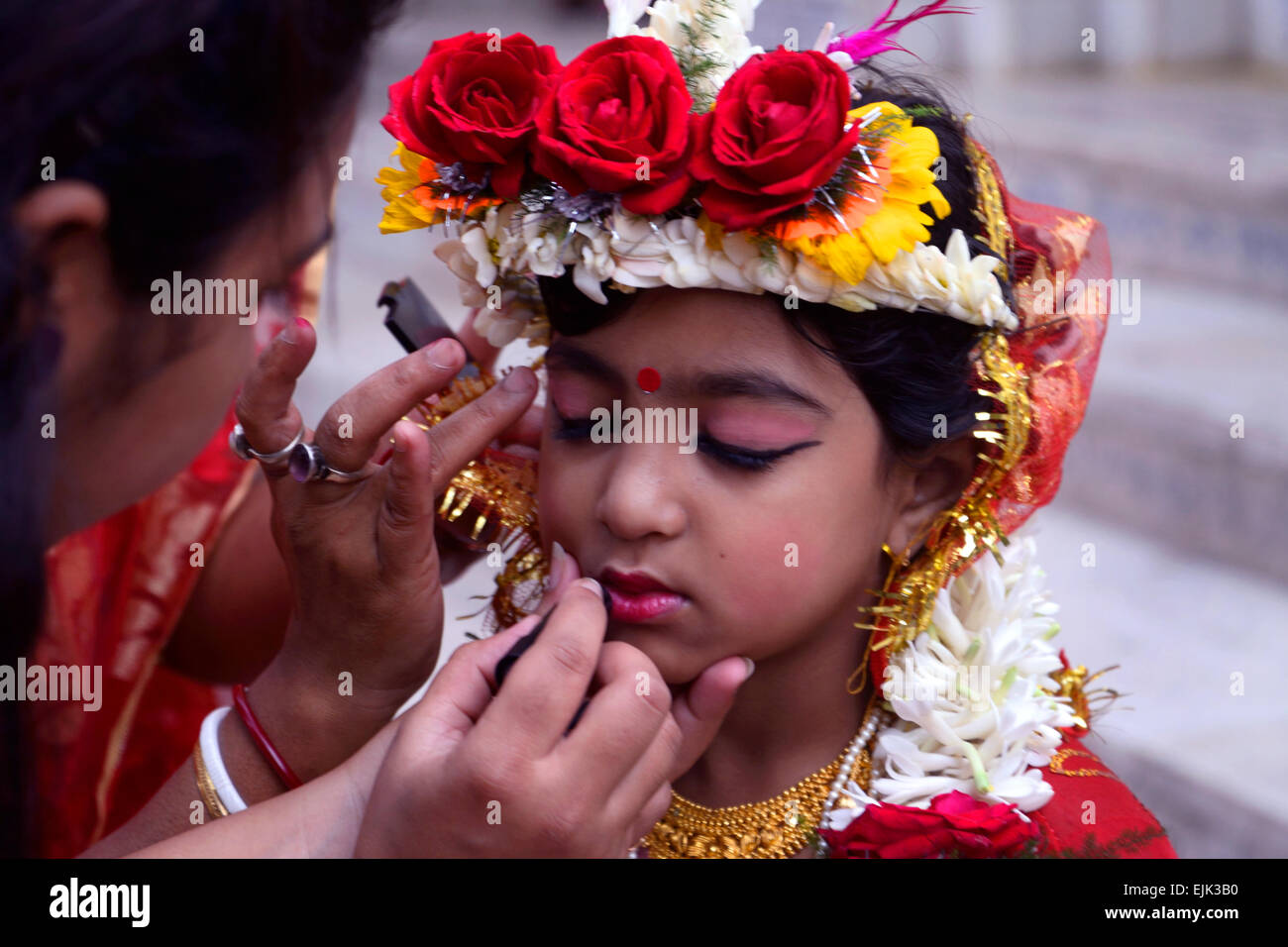 Kolkata, Inde. 30Th Mar, 2015. Une mère fait un maquillage sur son bébé comme l'un des Kumari. Il y a 2000 Kumari été adoré à Dakshinewar Adyapeath Ramkrishna Sangha, au cours de l'occasion de Basanti Puja ou Annapurna Puja. Kumari Puja est une tradition d'adorer les jeunes filles impubères, comme des manifestations de l'énergie féminine ou Devi dans la tradition religieuse hindoue. Credit : Saikat Paul/Pacific Press/Alamy Live News Banque D'Images